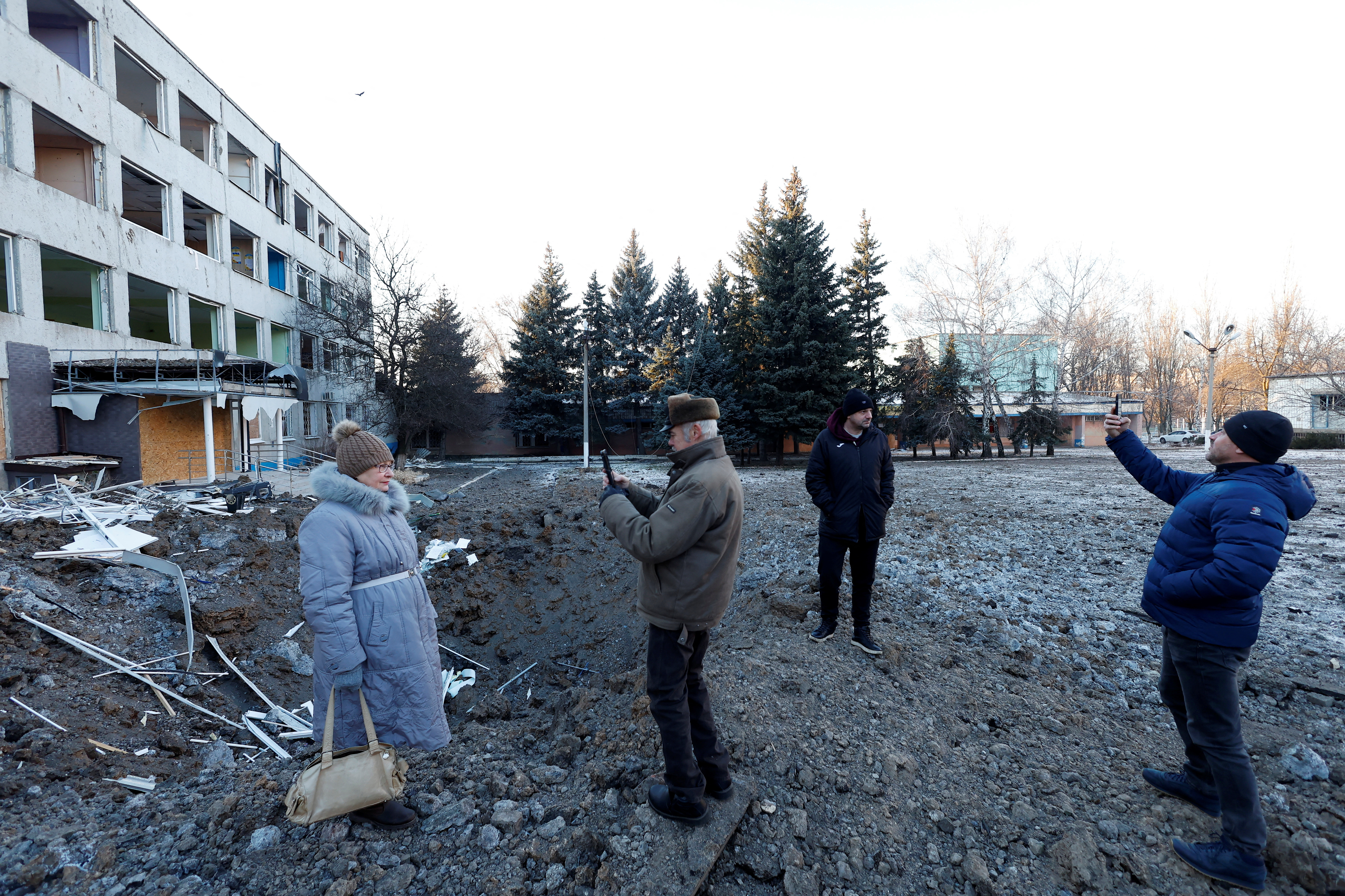 Vecinos toman fotos y selfies en la zona donde impactó el misil, a metros del edificio objetivo en Kramatorsk (Reuters)