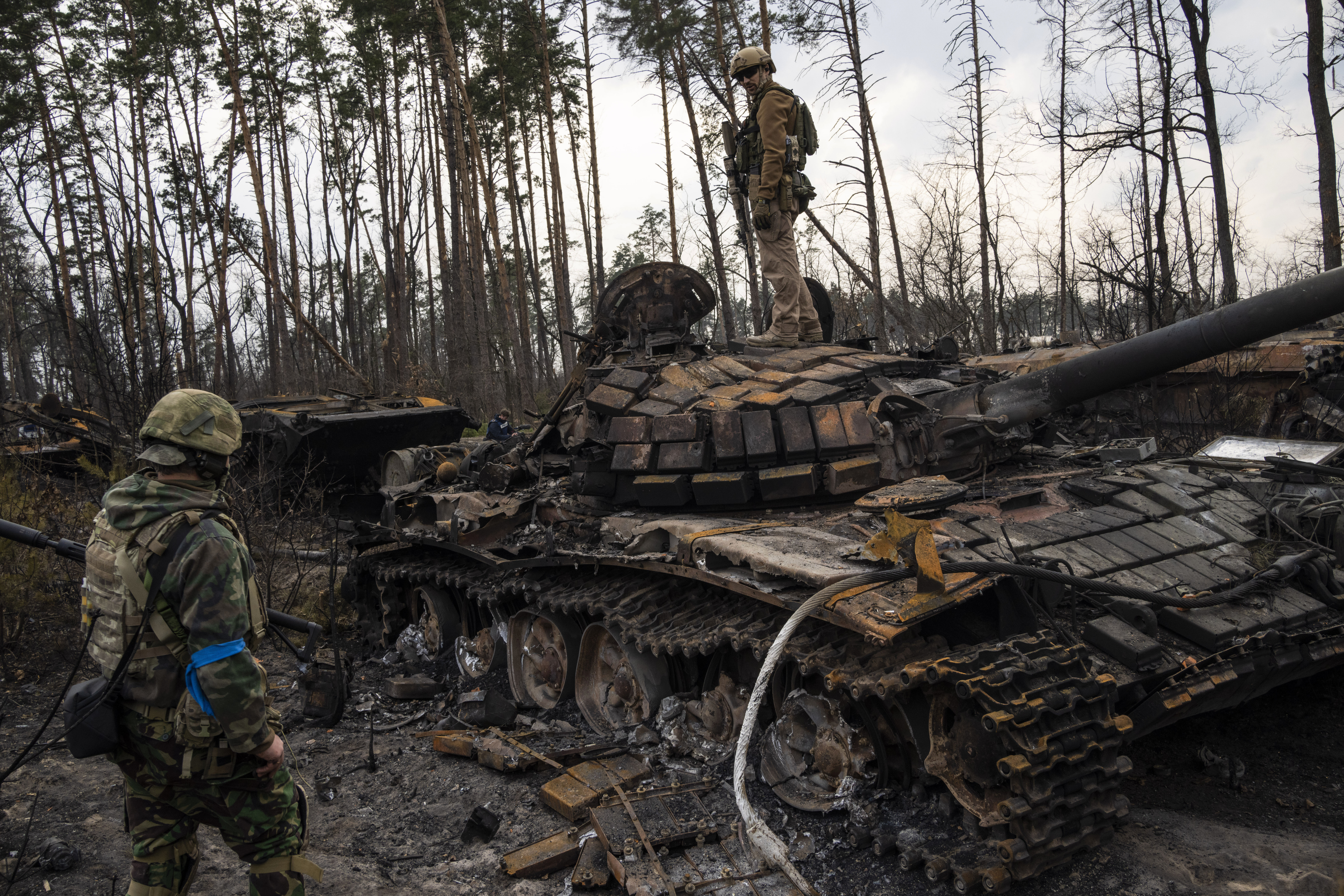 Un soldado ucraniano permanece encima de un tanque ruso destruido mientras otro lo mira (AP Foto/Rodrigo Abd/Archivo)