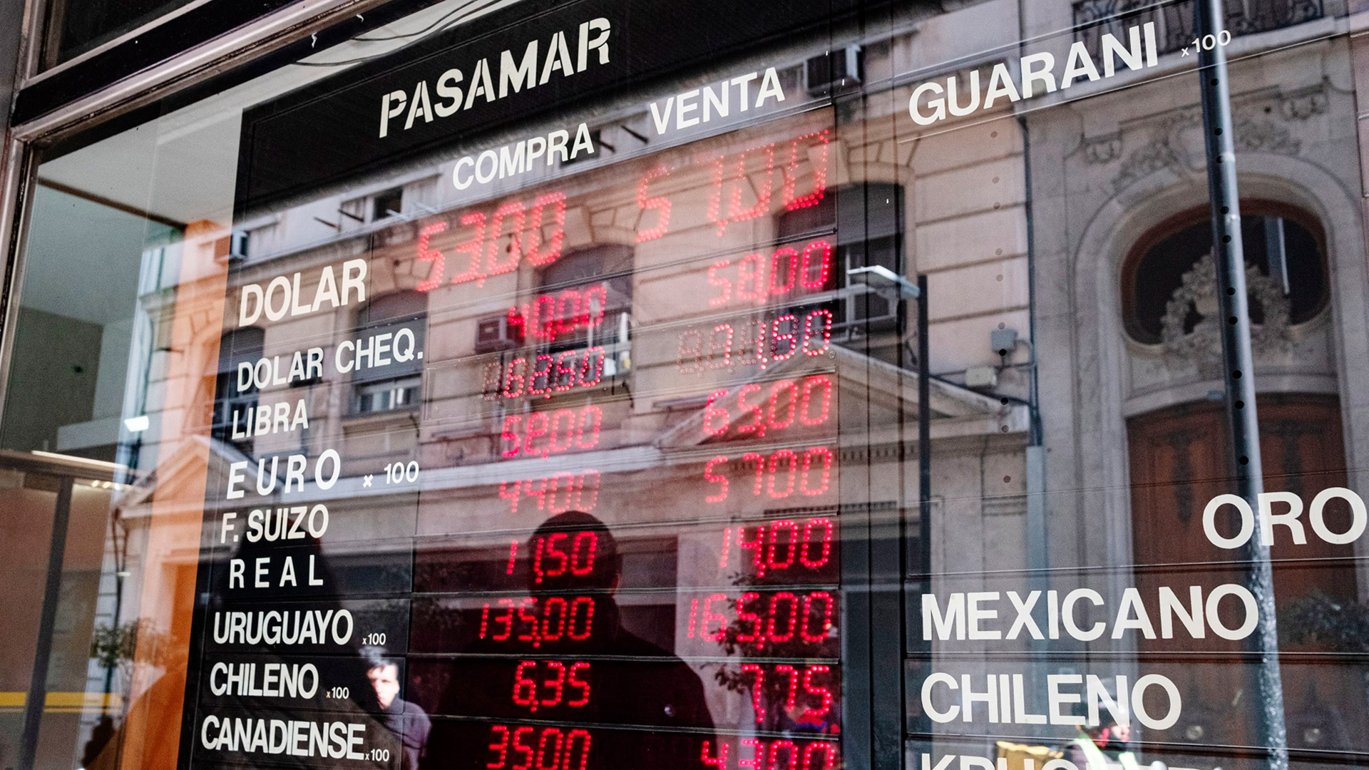 Currency exchange rates are displayed on an electronic board in a window in Buenos Aires.