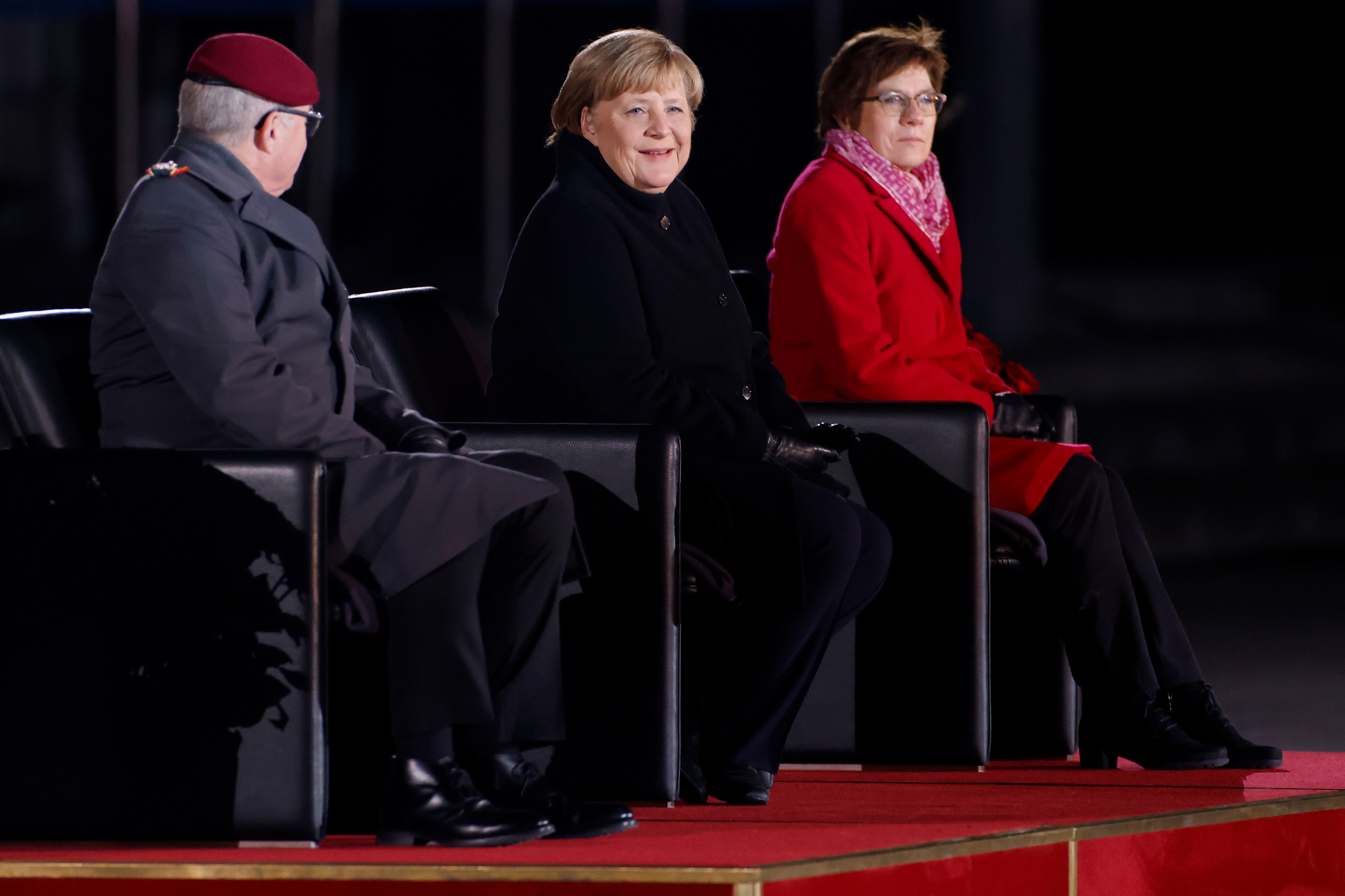 Merkel sonríe rodeada de la ministra de Defensa, Annegret Kramp-Karrenbauer, y una de las máximas autoridades militares de Alemania, el Inspector General Eberhard Zorn (Odd Andersen/Pool via REUTERS)