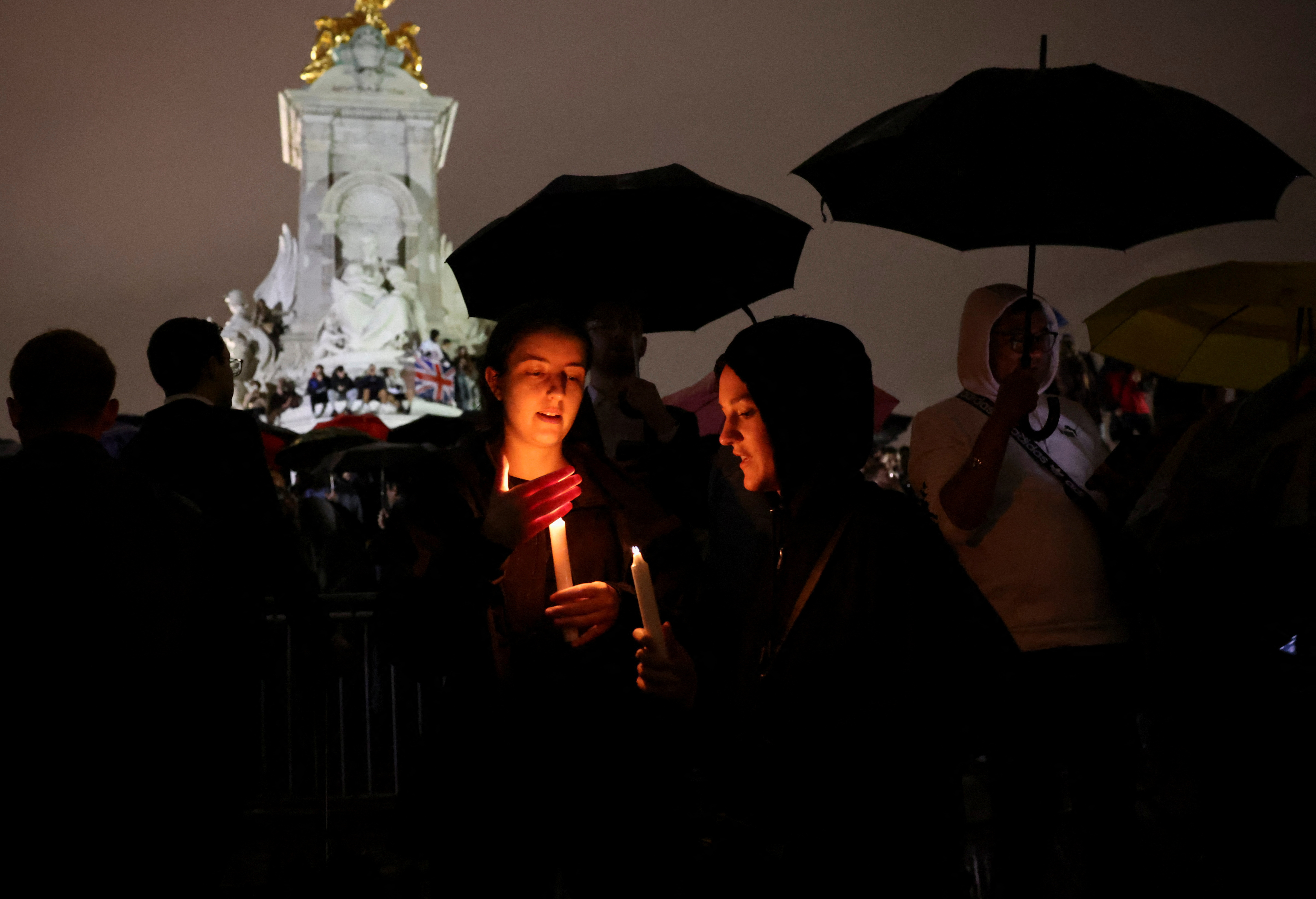 Dos jóvenes sostienen una vela en medio de los homenajes a la reina Isabel (REUTERS/Henry Nicholls)