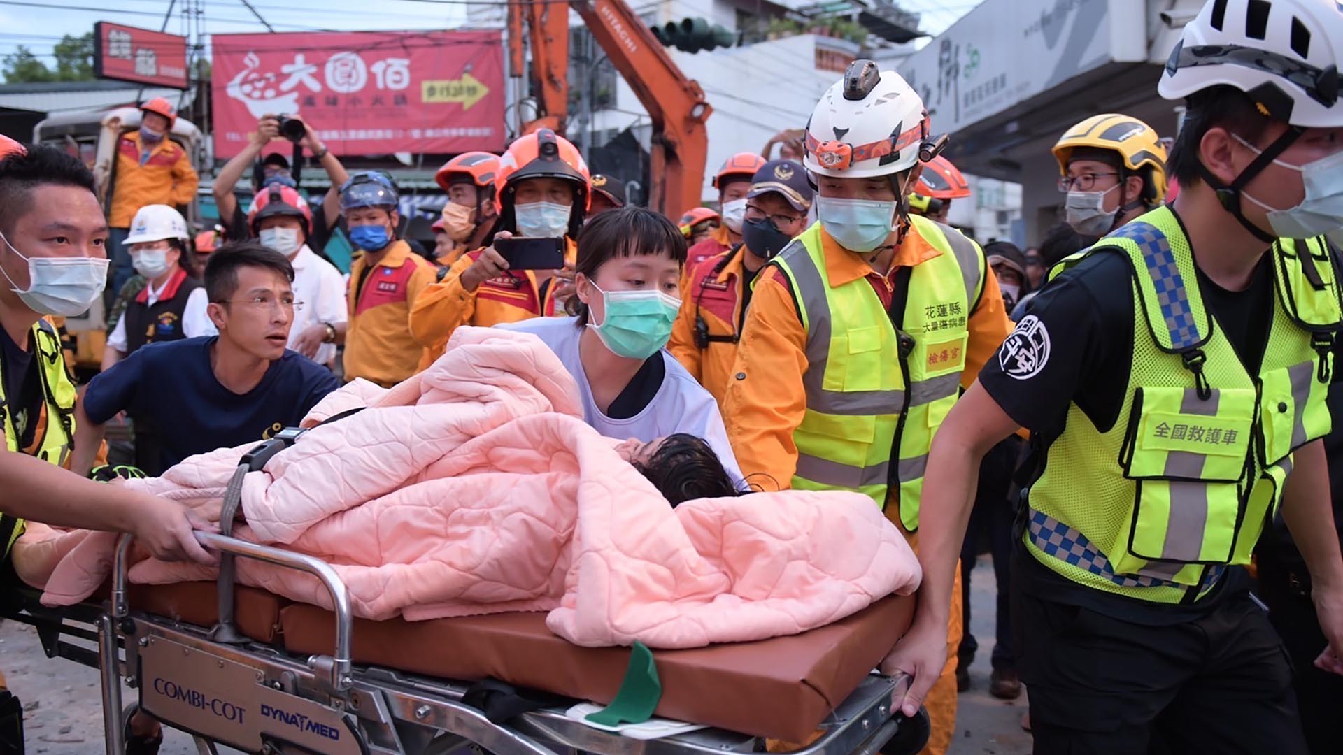 En esta foto proporcionada por el gobierno de la ciudad de Hualien, una víctima atrapada es llevada en una camilla cuando la víctima fue encontrada y rescatada por los bomberos de un edificio derrumbado en el municipio de Yuli, condado de Hualien, este de Taiwán, el domingo 18 de septiembre de 2022.  (Gobierno de la ciudad de Hualien vía AP)

