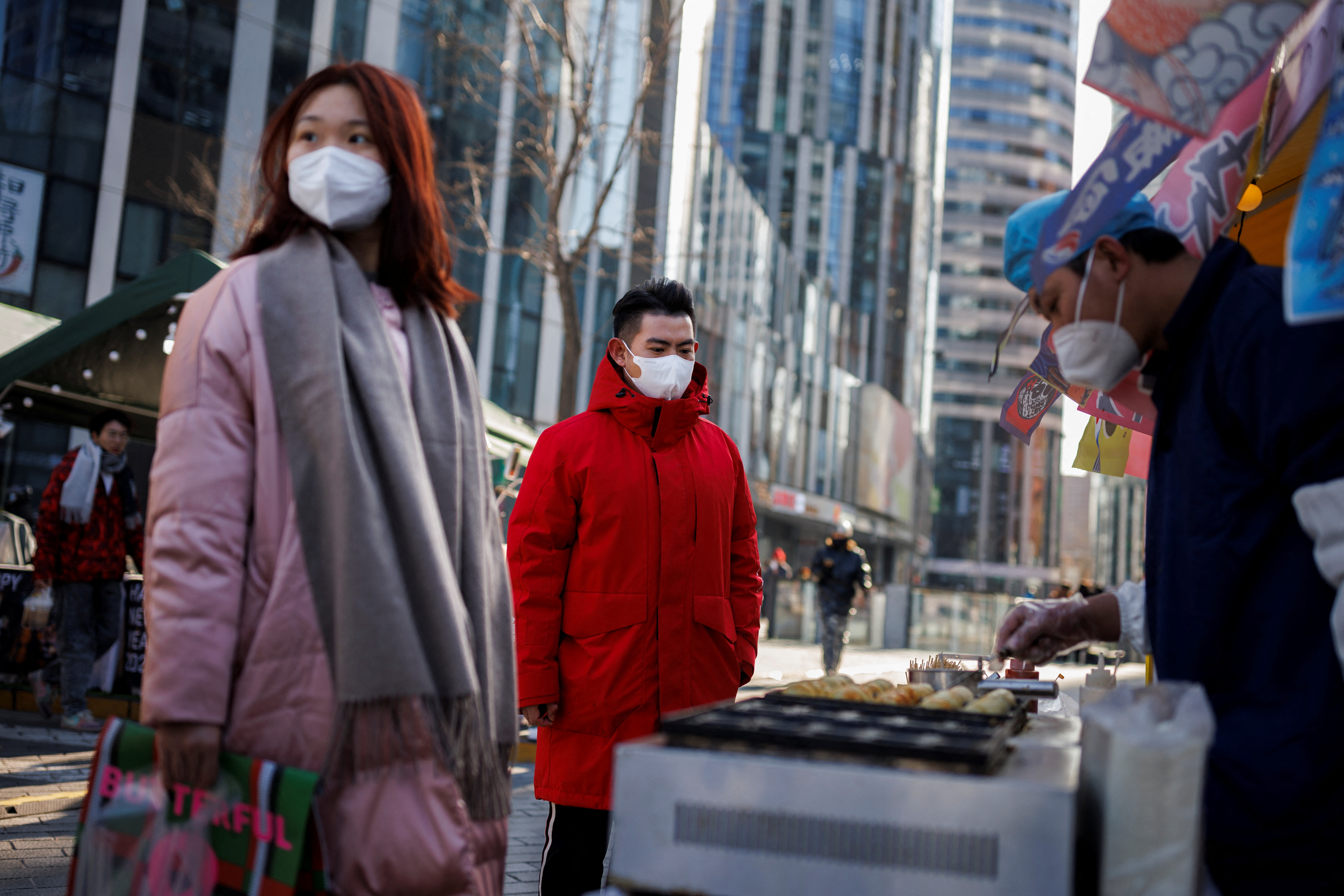 Pedestrians in Beijing, in the reopening of commercial areas amid the outbreak (Reuters)