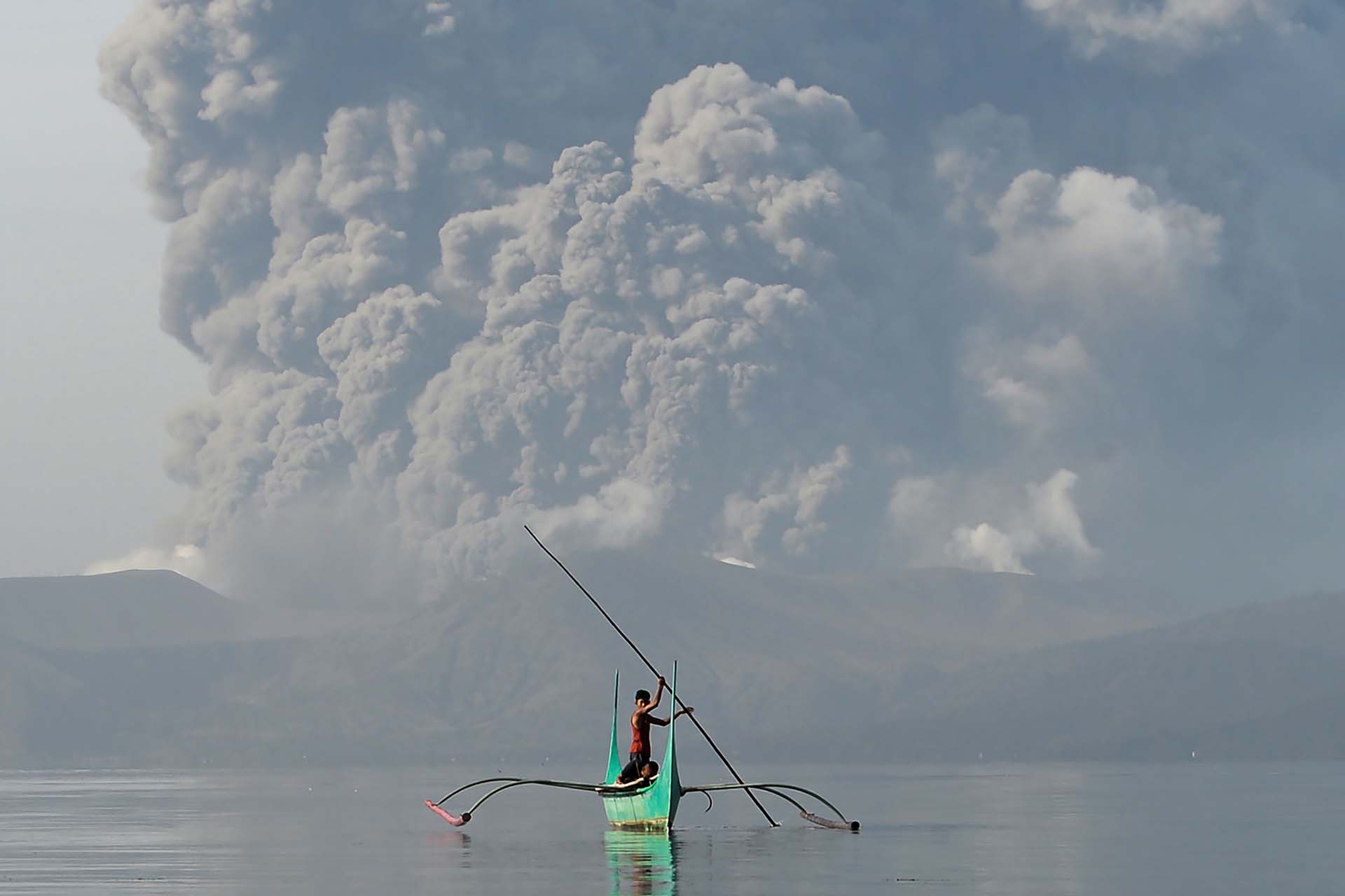 Un joven escapa en su canoa de la erupcion del volcán Tanauan en Filipinas (13 de enero) 