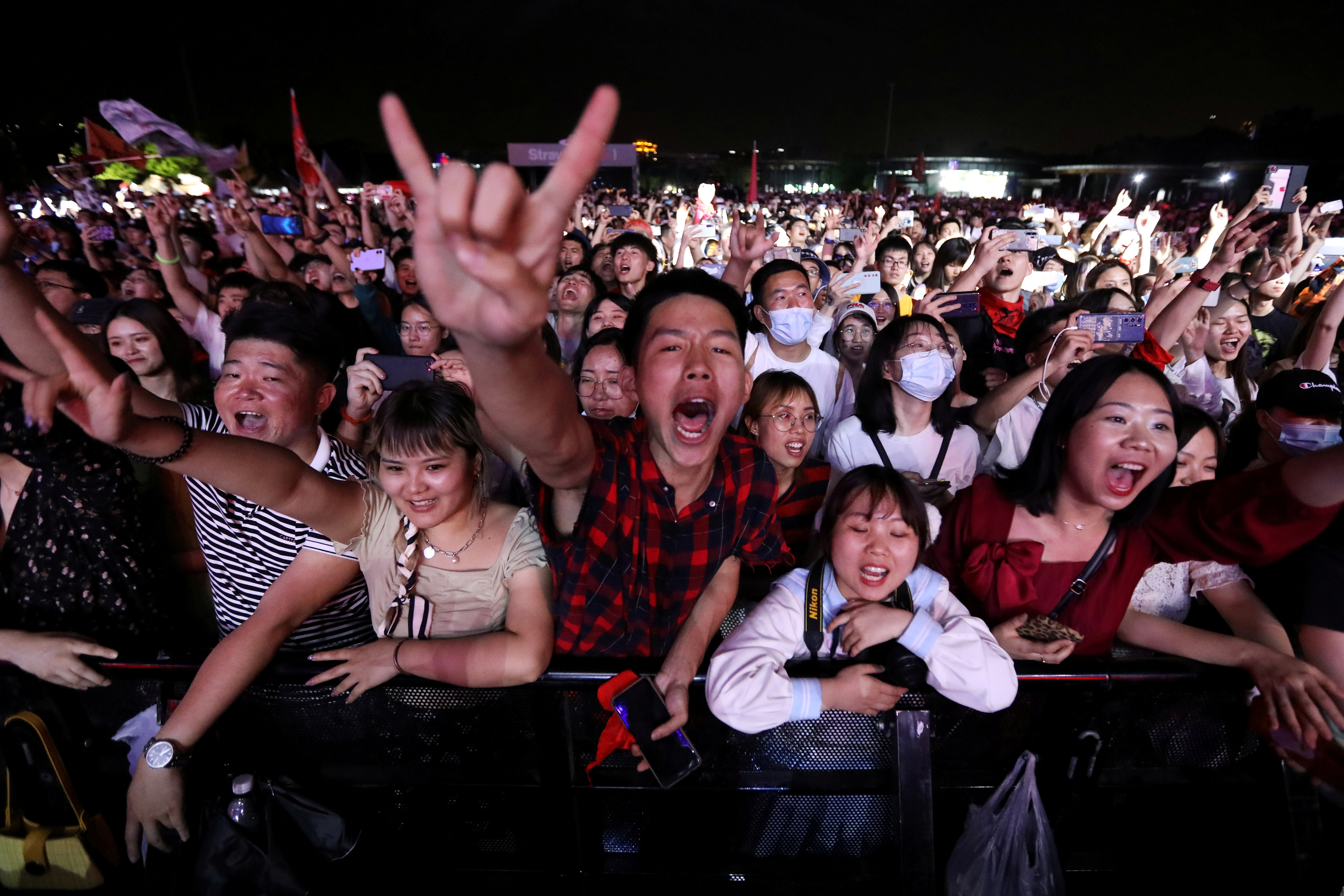 Personas asisten a un show de una banda de rock en el Strawberry Music Festival durante las vacaciones del Día del Trabajo en Wuhan, provincia de Hubei, China, el 1 de mayo de 2021. REUTERS / Tingshu Wang
