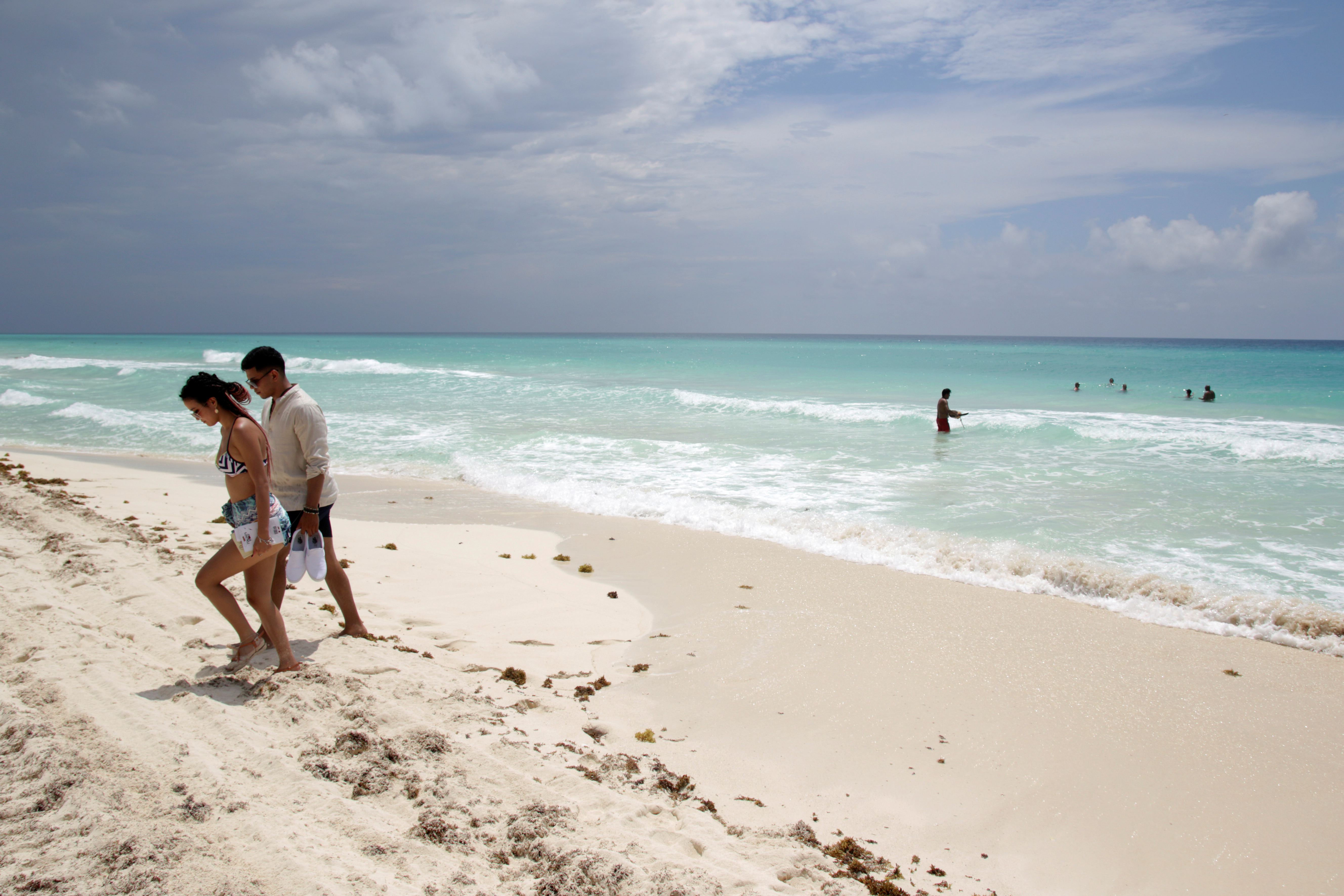 Los turistas se relajan en una playa después de las autoridades locales impusieron estrictas medidas sanitarias para reabrir gradualmente a pesar de la pandemia de la enfermedad por coronavirus (COVID-19), en Cancún, México, el 11 de junio de 2020. Foto: Reuters.