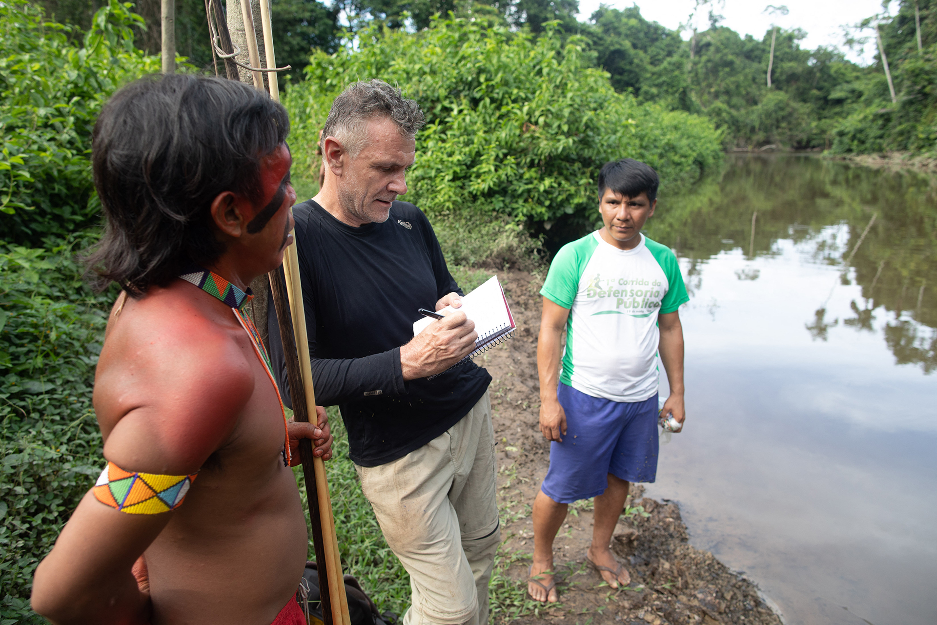 Dom Phillips habla con dos indígenas en Aldeia Maloca Papiú (Joao LAET / AFP)