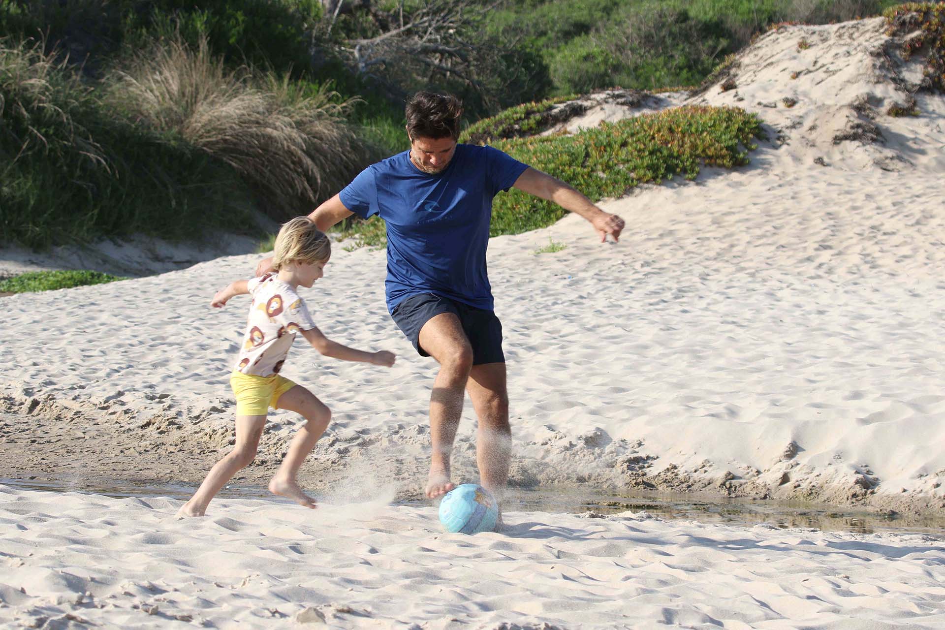Guillermo Andino y su hijo Ramón, jugando al fútbol en la playa