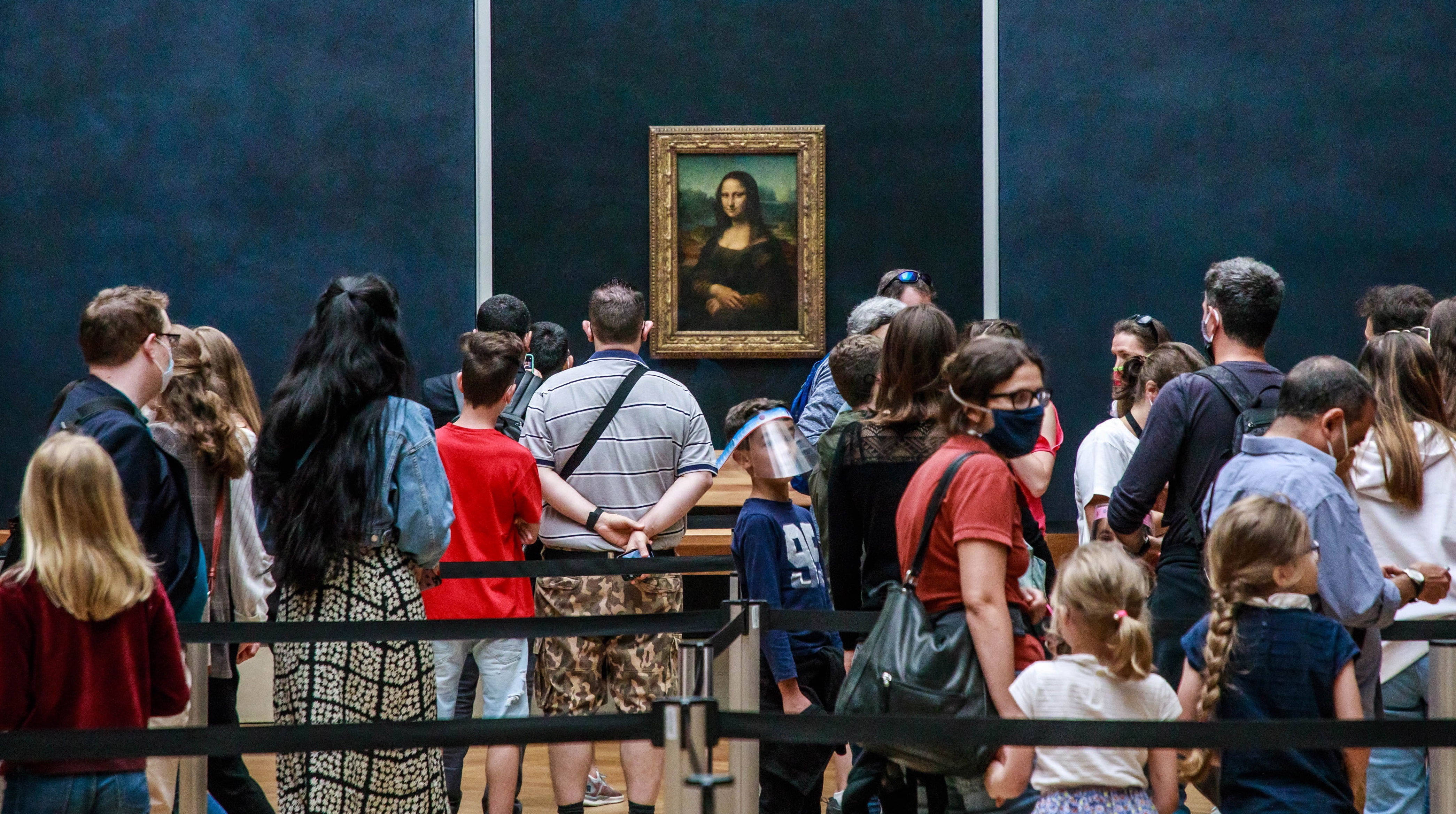 Visitantes ataviados con mascarillas esperan para ver "La Gioconda", del artista italiano Leonardo Da Vinci