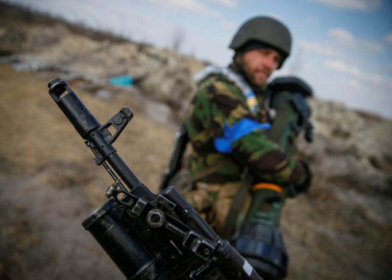 Un soldado ucraniano sostiene un arma antitanques de última generación (NLAW) frente a otro soldado que sostiene un rifle en el frente de batalla al norte de la región de Kiev, Ucrania (REUTERS/Gleb Garanich)