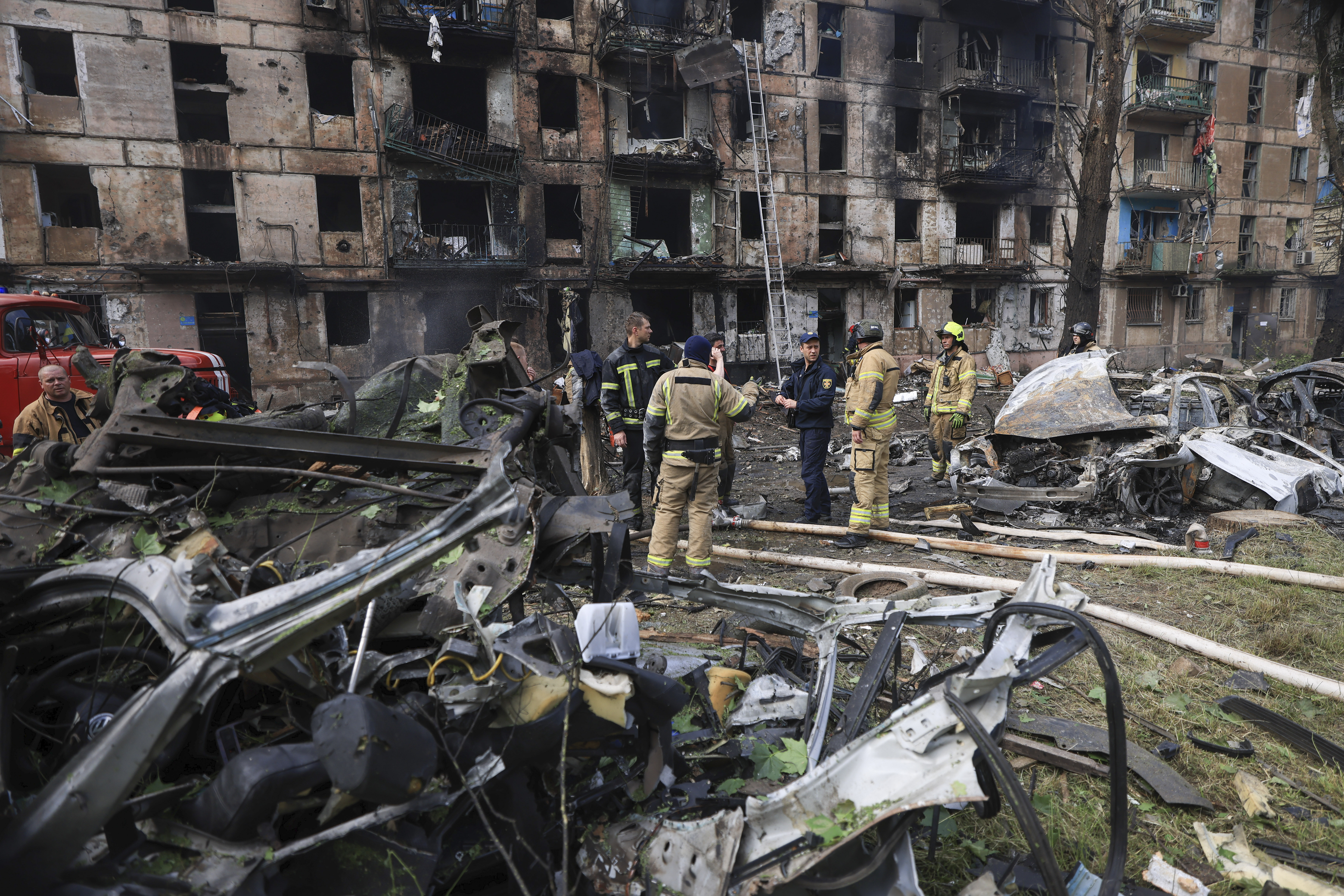 Trabajadores de los servicios de emergencias inspeccionan los daños causados en un edificio de varias plantas por un ataque ruso, en Krivói Rog, Ucrania, el 13 de junio de 2023. (AP Foto/Andriy Dubchak)