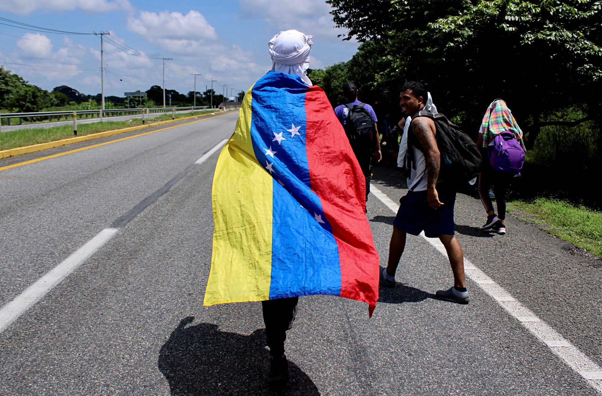 Un migrante sostiene una bandera venezolana mientras cruza a pie el estado de Chiapas (Foto: Reuters)