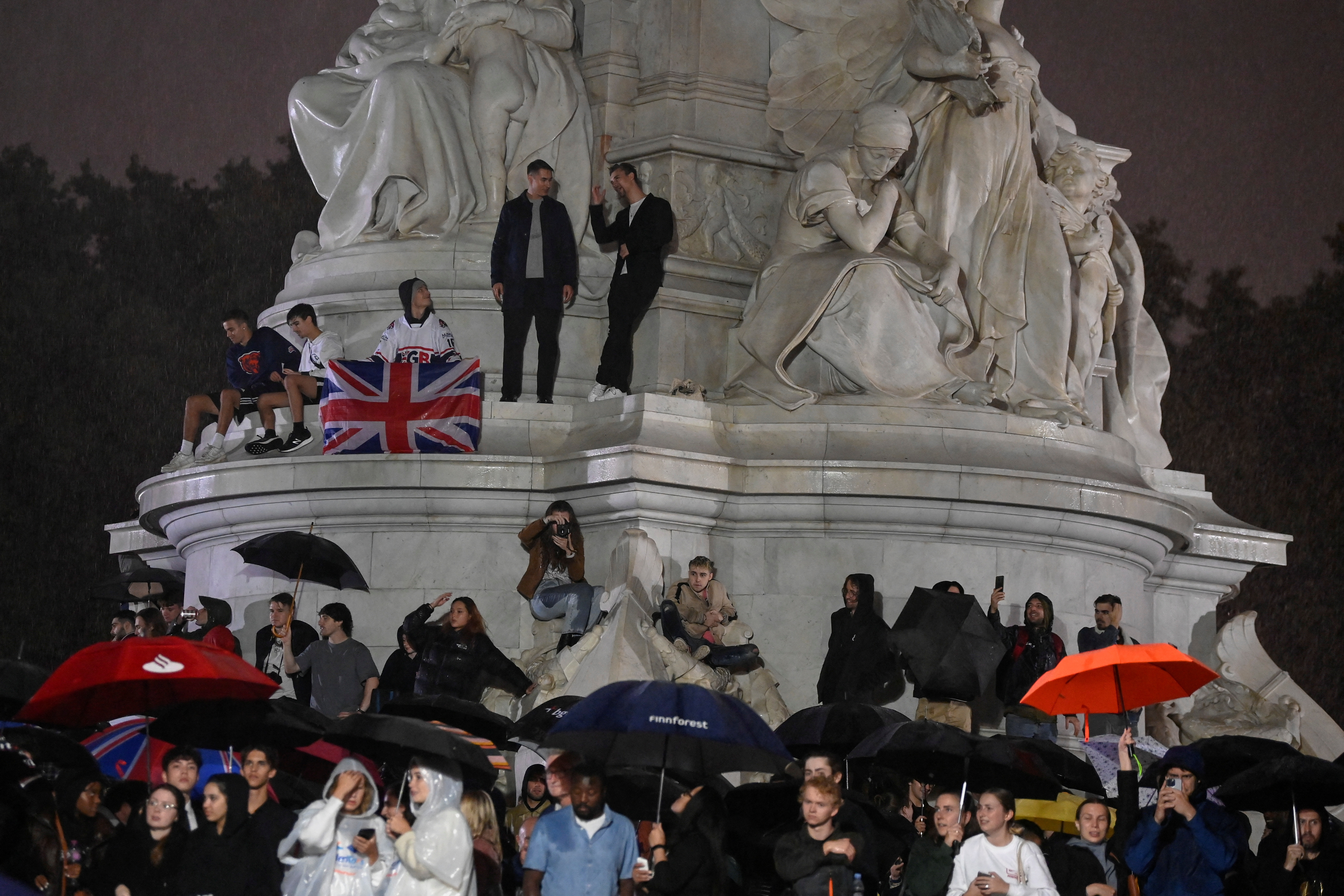 Las multitudes se paran cerca del monumento a la reina Victoria mientras se reúnen alrededor del Palacio de Buckingham (REUTERS/Toby Melville)