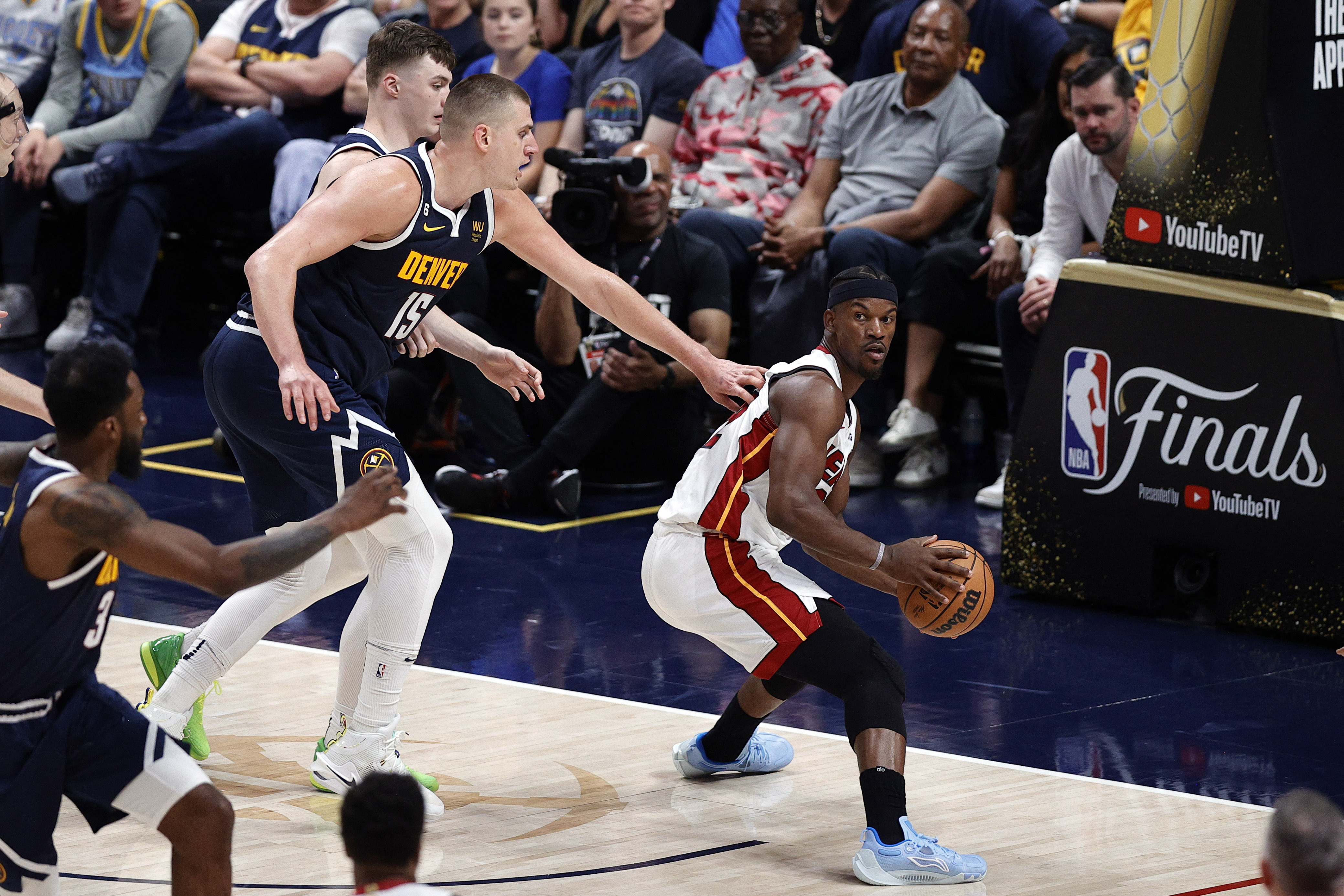 Jun 4, 2023; Denver, CO, USA; Miami Heat forward Jimmy Butler (22) controls the ball against Denver Nuggets center Nikola Jokic (15) and guard Christian Braun (0) in the second half in game two of the 2023 NBA Finals at Ball Arena. Mandatory Credit: Isaiah J. Downing-USA TODAY Sports