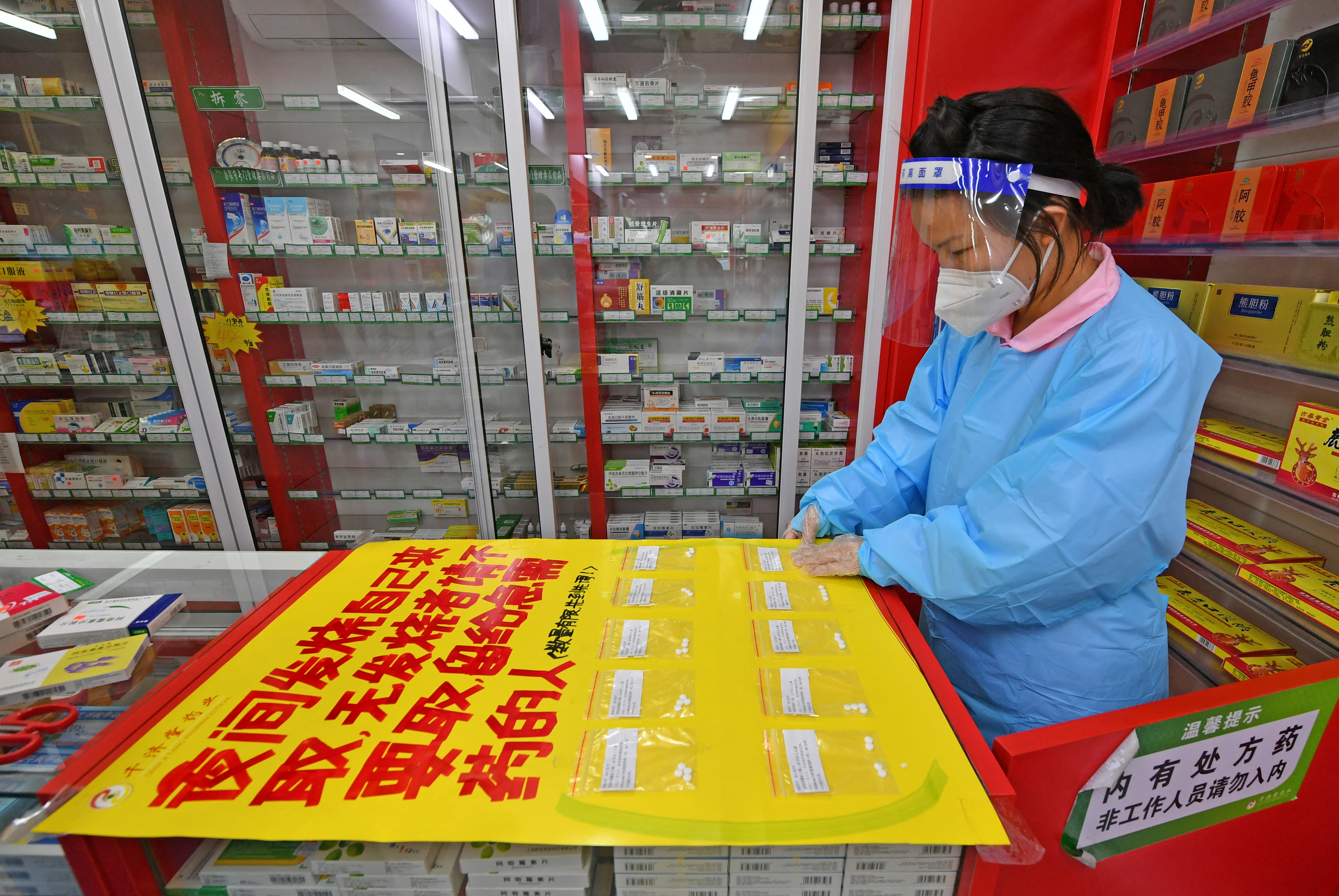 Un empleado farmacéutico prepara pastillas medicamentos antifebriles para ofrecer gratis a las personas que lñas necesitan por estar contagiados de coronavirus (cnsphoto via REUTERS)