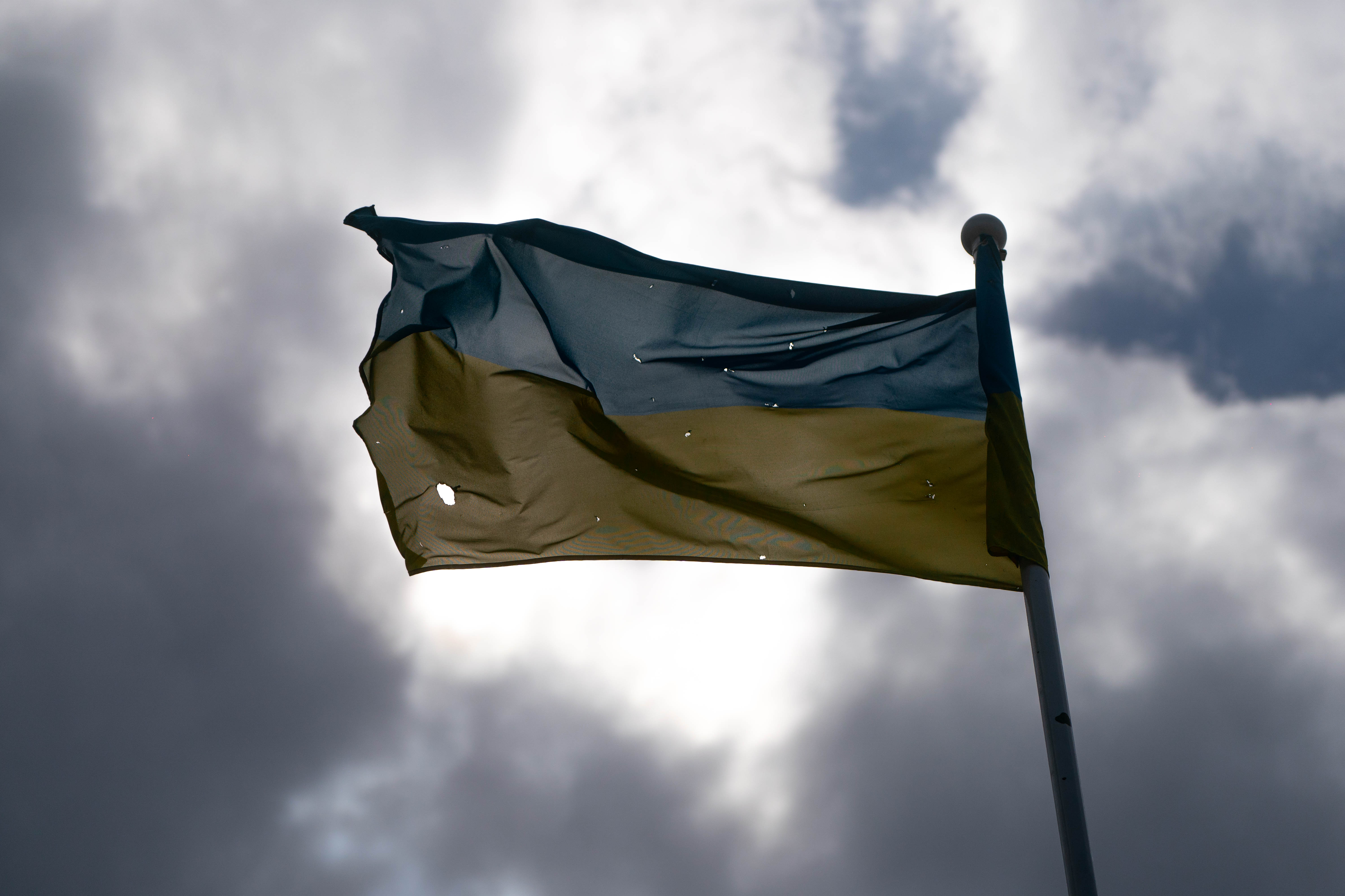 Una bandera Ucraniana atravesada por las balas, flamea en la ciudad de Irpin.