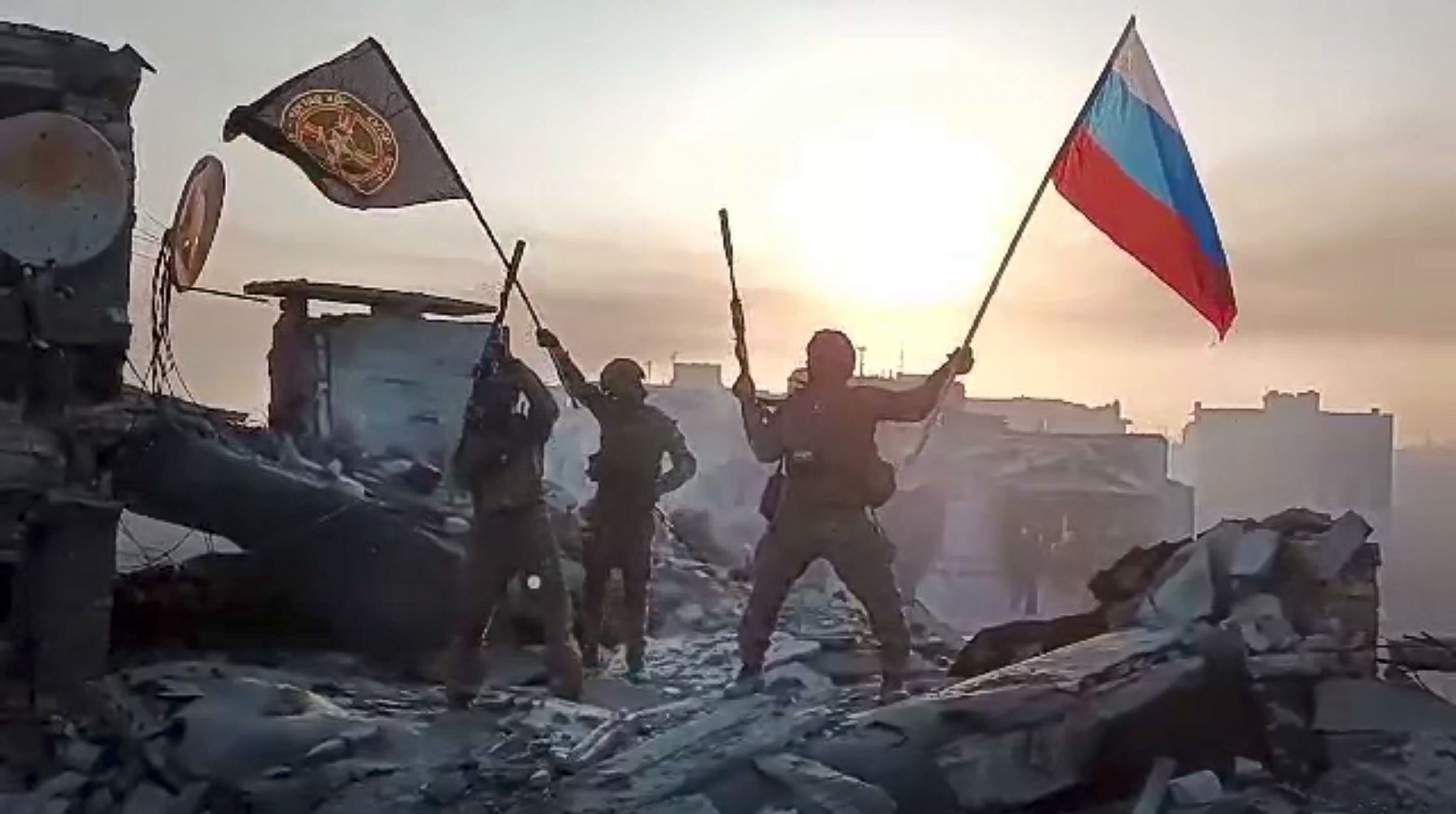 Miembros del contratista militar privado ruso Grupo Wagner ondean una bandera de Rusia y del Grupo Wagner sobre un edificio dañado en Bakhmut, Ucrania  (Servicio Prigozhin de Prensa vía AP, Archivo)