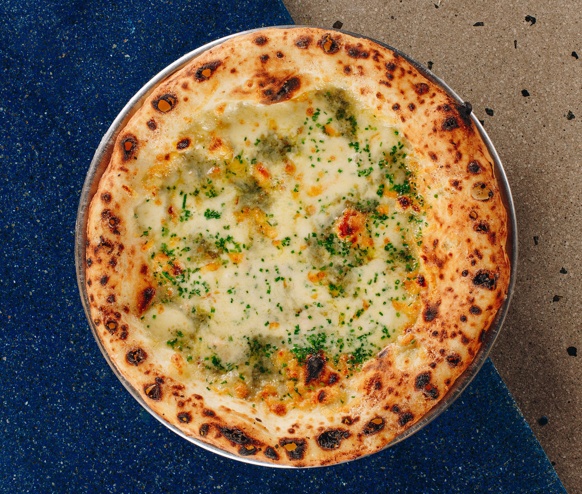 Pizza de cuatro quesos: mozzarella filante, mozzarella fior di latte, provolone y queso azul 