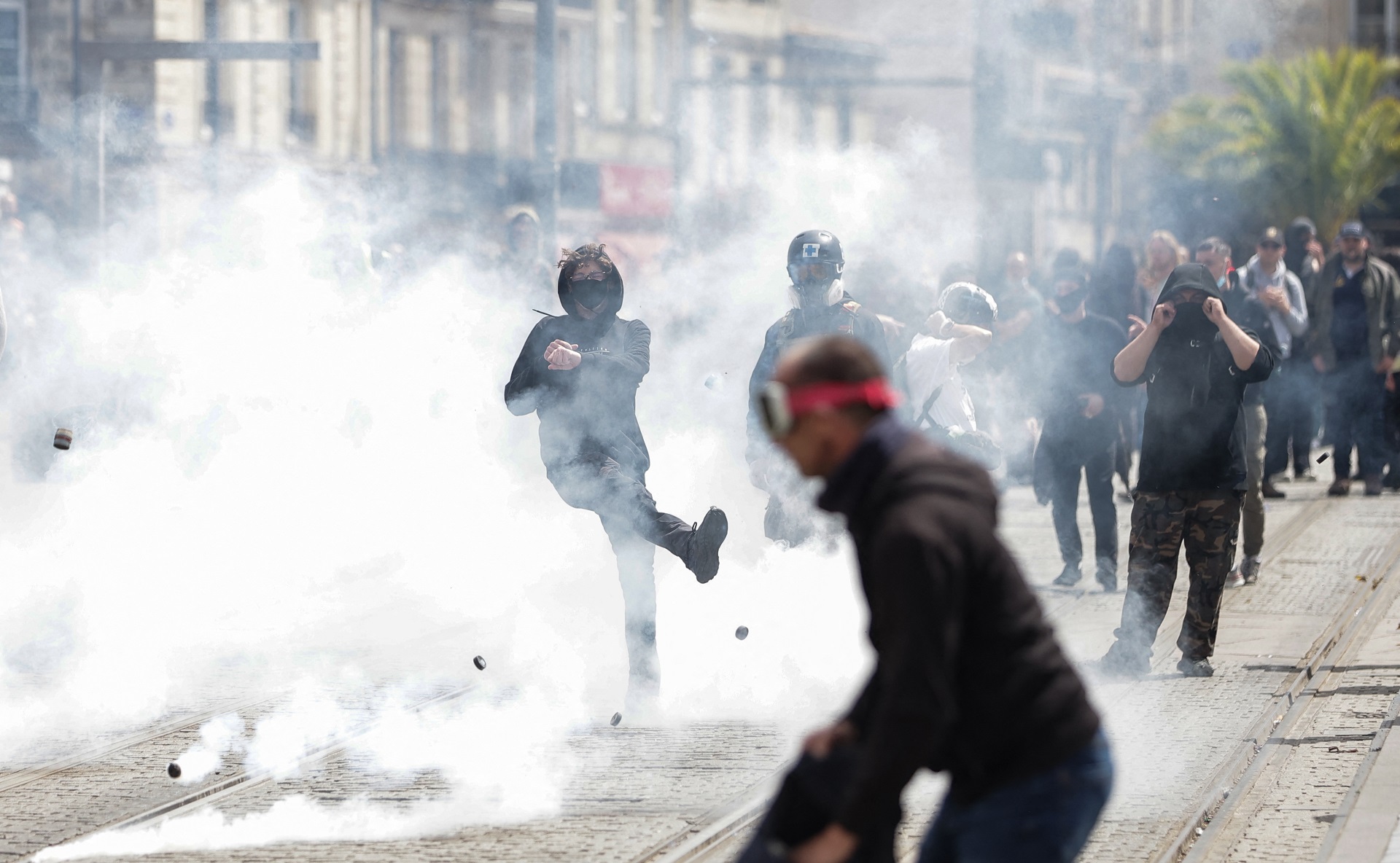 Manifestante patea una lacrimógena en Bordeaux (AFP)