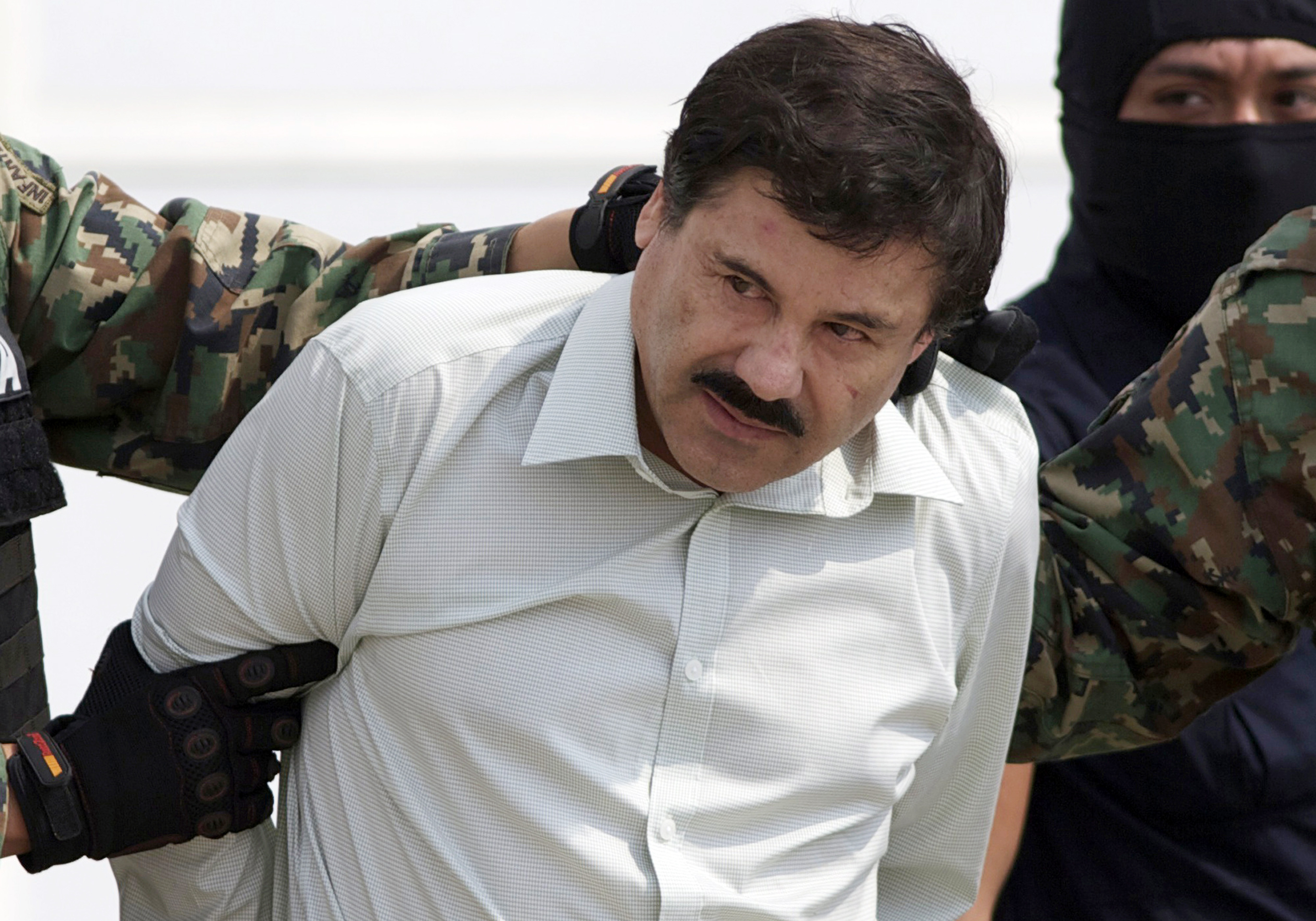 FILE - In this Feb. 22, 2014 file photo, Joaquin "El Chapo" Guzmán, head of the Sinaloa Cartel in Mexico, is escorted to a helicopter in Mexico City after his capture.  Mexican President Andrés Manuel López Obrador said on Wednesday, January 18, 2023, that the government will analyze the request for "El Chapo" to be returned to Mexico due to the alleged inhumane conditions in which he would find himself in a US prison where he is serving a life sentence.  (AP Photo/Eduardo Verdugo, File)