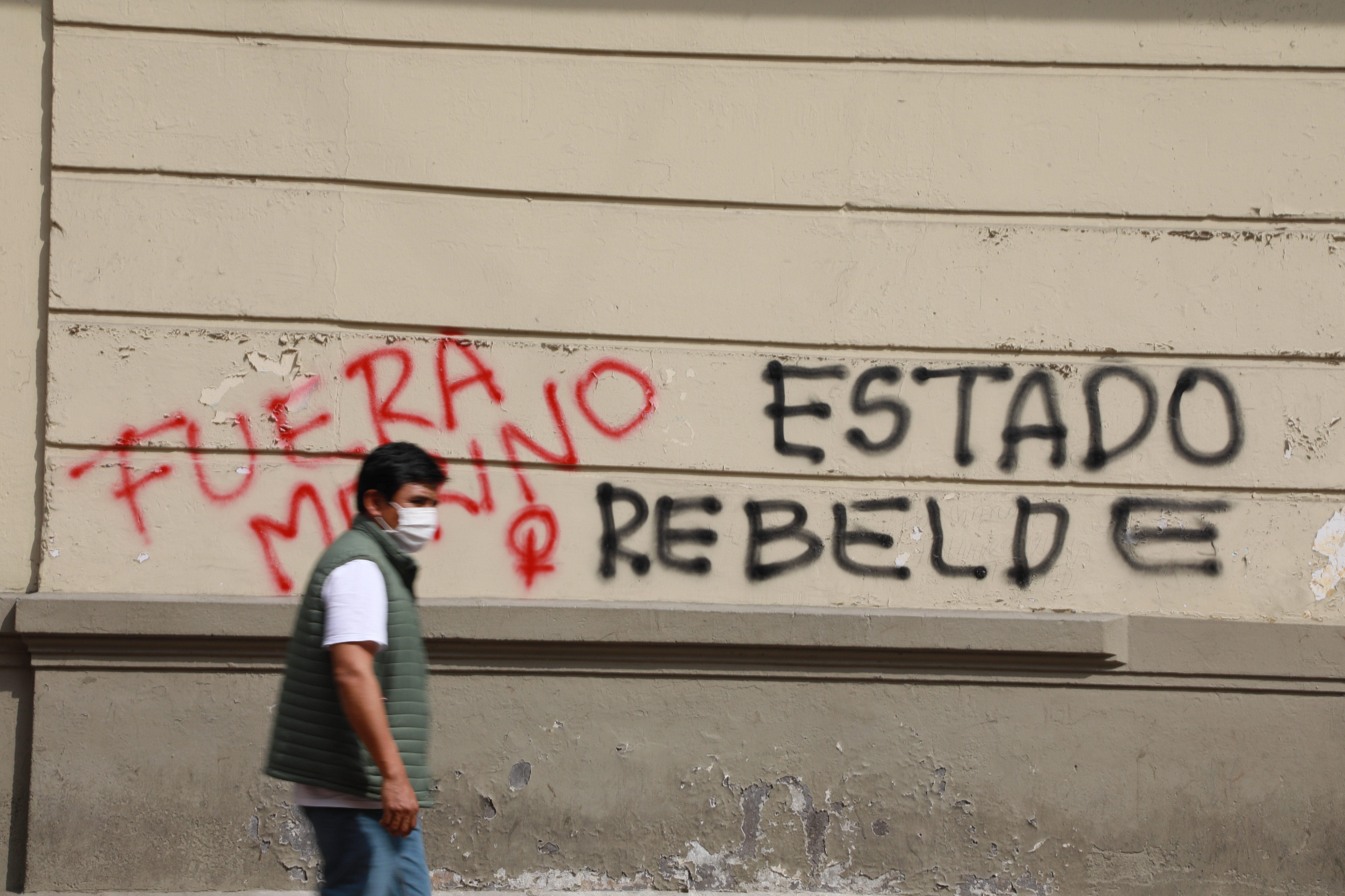 Un hombre camina hoy, miércoles frente a un muro con pintas realizadas por manifestantes en el centro histórico de Lima (Perú). EFE/Juan Ponce Valenzuela