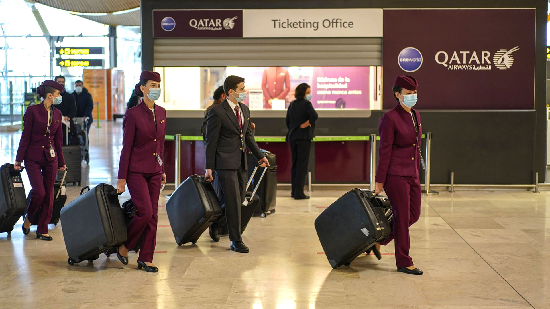 Flight attendants and crew from Qatar Airways wheel luggage through the departures hall at Madrid Barajas airport, operated by Aena SA, in Madrid, Spain, on Thursday, Dec. 24, 2020. The coronavirus pandemic left fleets of planes grounded and caused air passenger traffic to slump as much as 94%. Photographer: Paul Hanna/Bloomberg