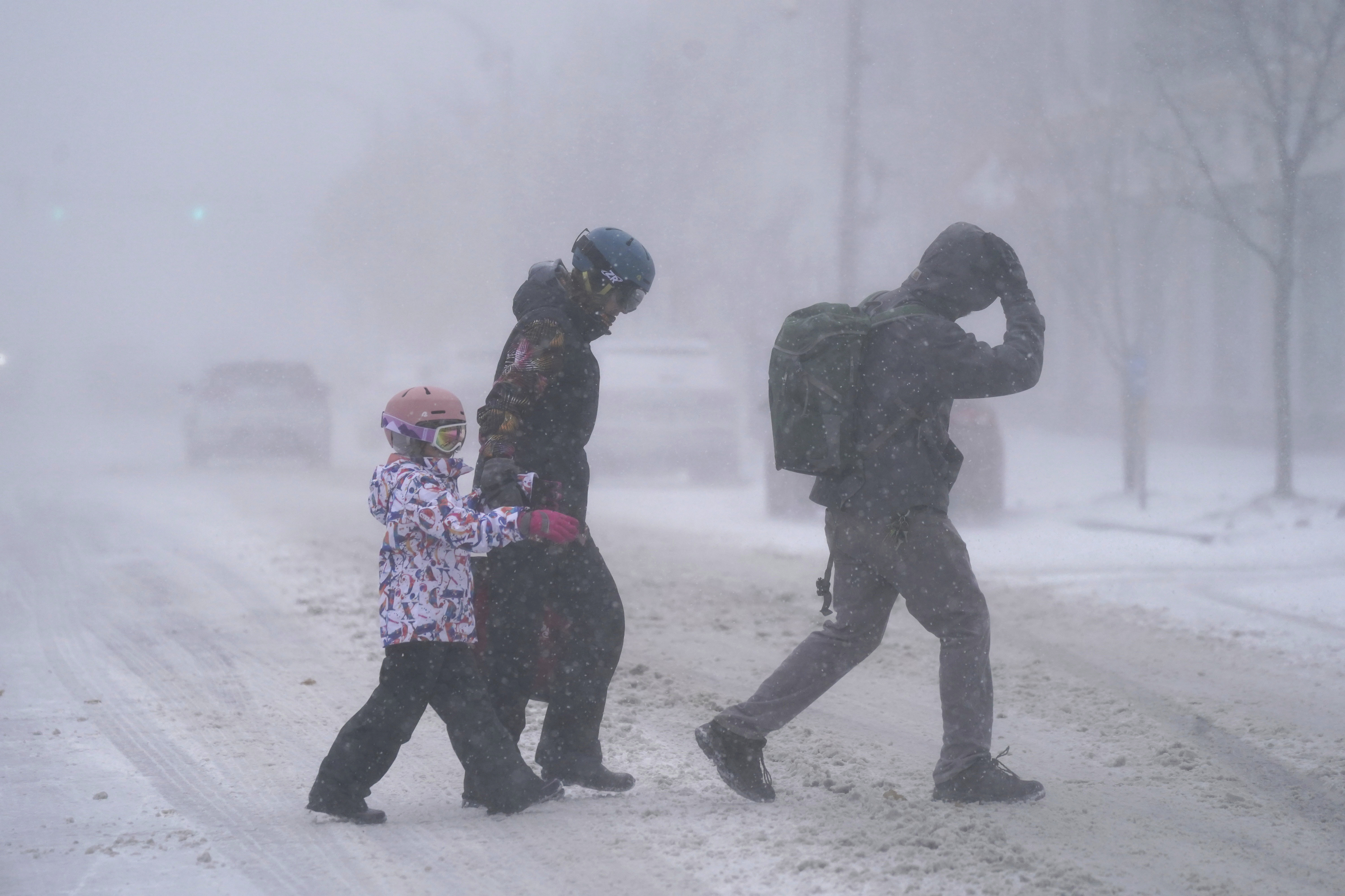 La familia Firestone cruza la Avenida Elmwood en Buffalo, Nueva York, bajo la tormenta de nieva