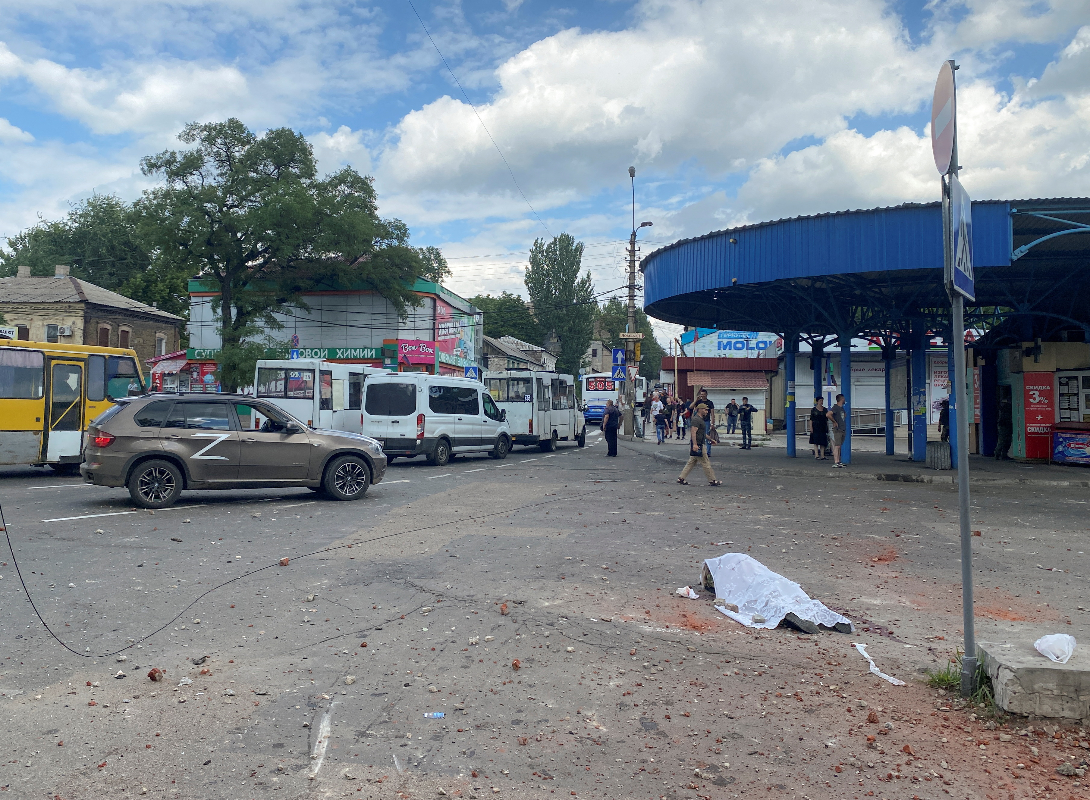 IMÁGENES SENSIBLES: El cuerpo de una persona muerta durante un bombardeo en la estación de autobuses yace en la calle en la ciudad de Donetsk, Ucrania, controlada por los separatistas, el 14 de julio de 2022.  REUTERS/Kazbek Basayev