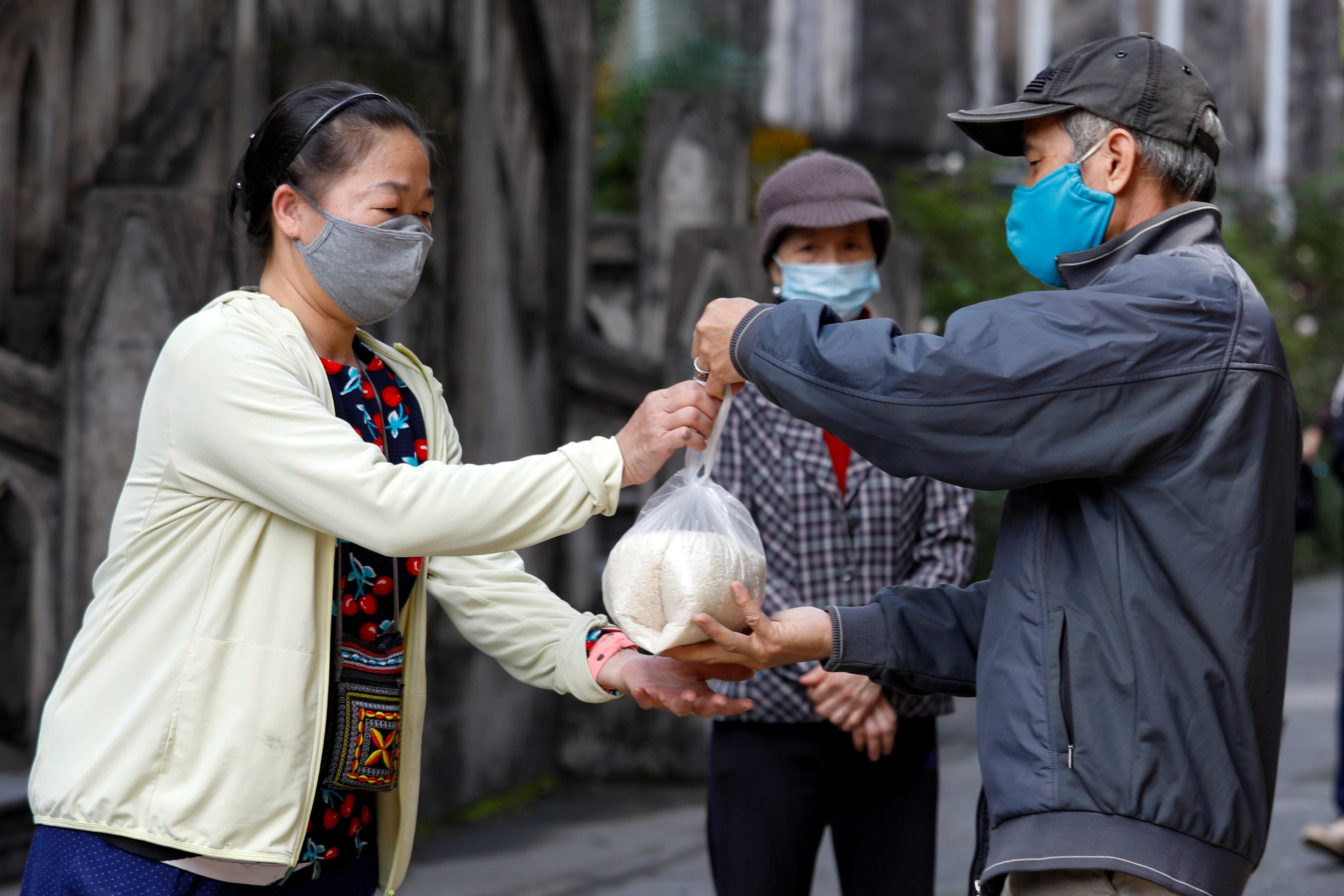 Personas reciben donaciones de arroz frente a la catedral de San José, en Hanoi