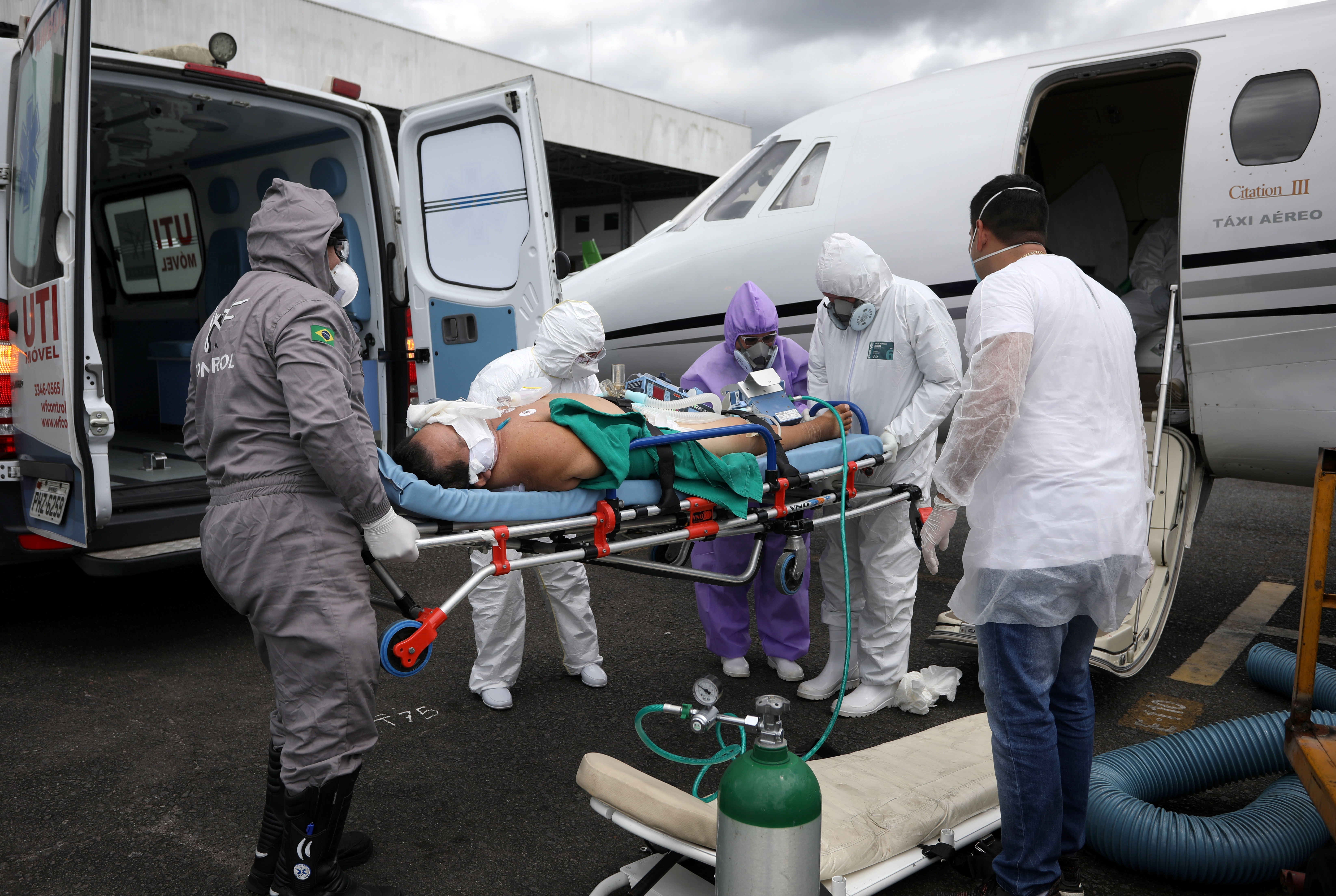 Otaviano Batista, de 67 años, un paciente que sufre la enfermedad coronavirus (COVID-19), es ayudado por trabajadores de la salud al salir de un avión de la UCI, que llega de Tabatinga a Manaos, Brasil, el 18 de mayo de 2020. REUTERS/Bruno Kelly