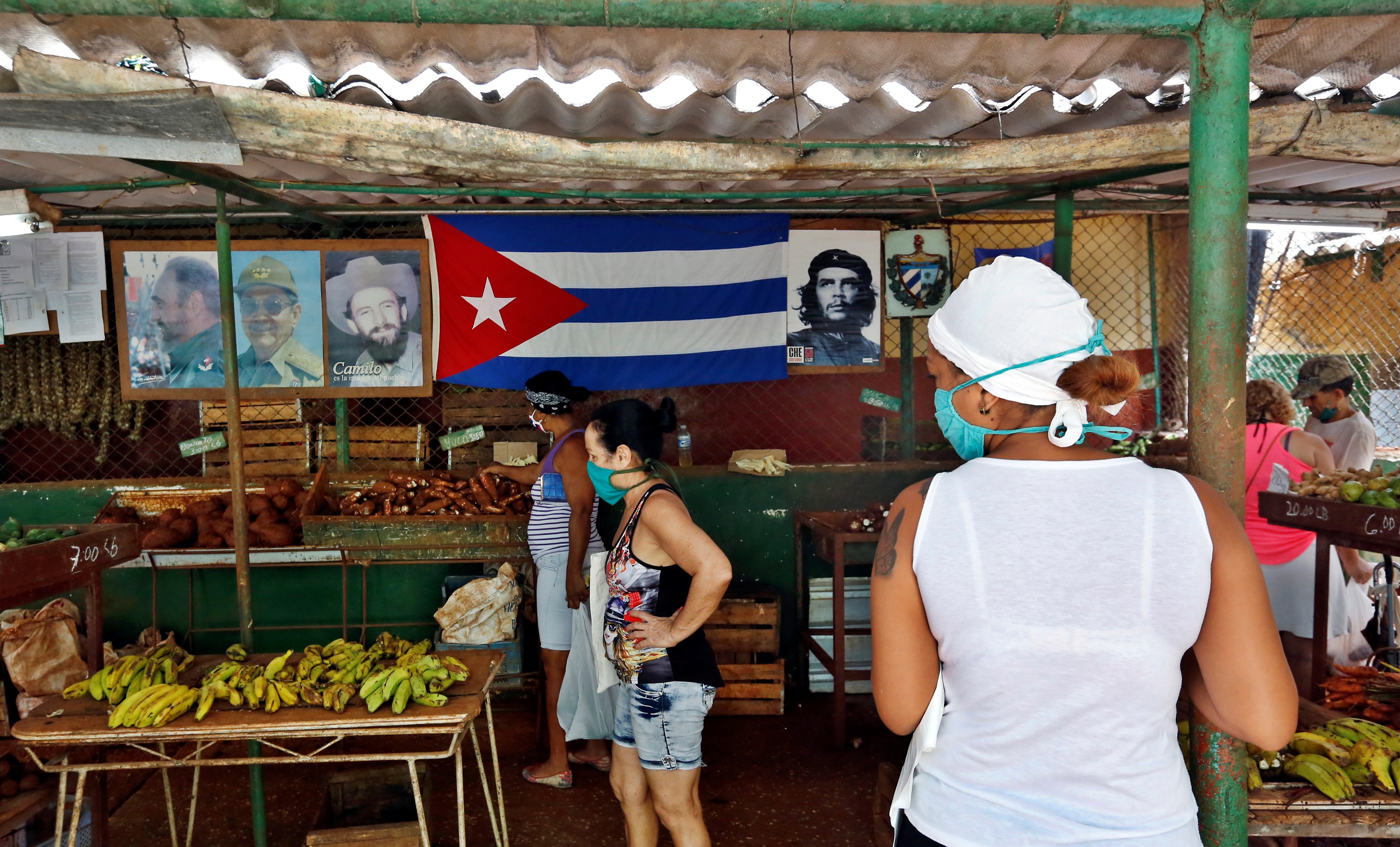 Varias personas que observan productos dentro de un agro mercado, en La Habana (Cuba)
