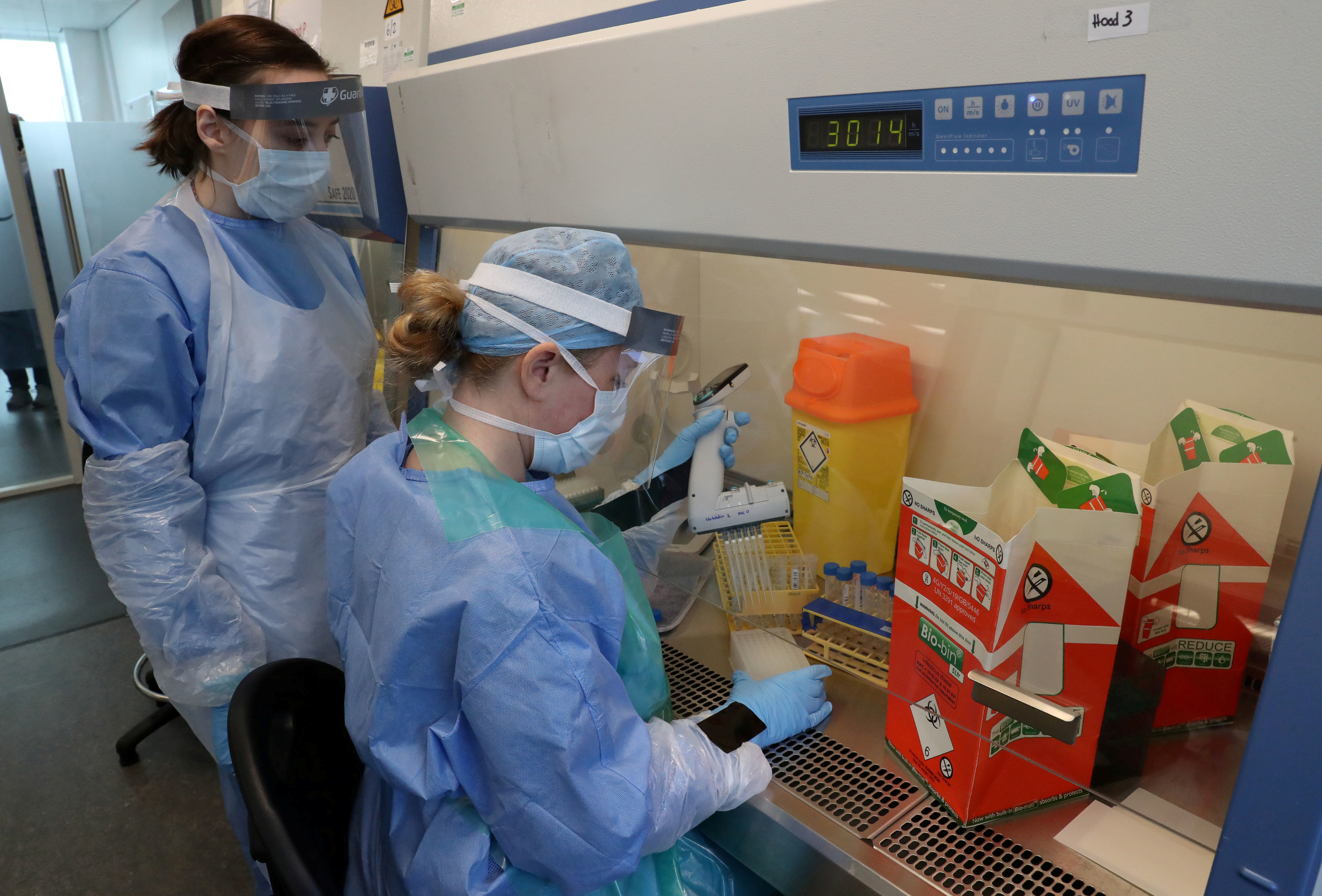 Técnicos laboratoristas llevan a cabo una transferencia de muestra durante la apertura del nuevo laboratorio de pruebas COVID-19, en medio de la epidemia de la enfermedad por coronavirus, en el Queen Elizabeth University Hospital, en Glasgow, Gran Bretaña (Reuters)
