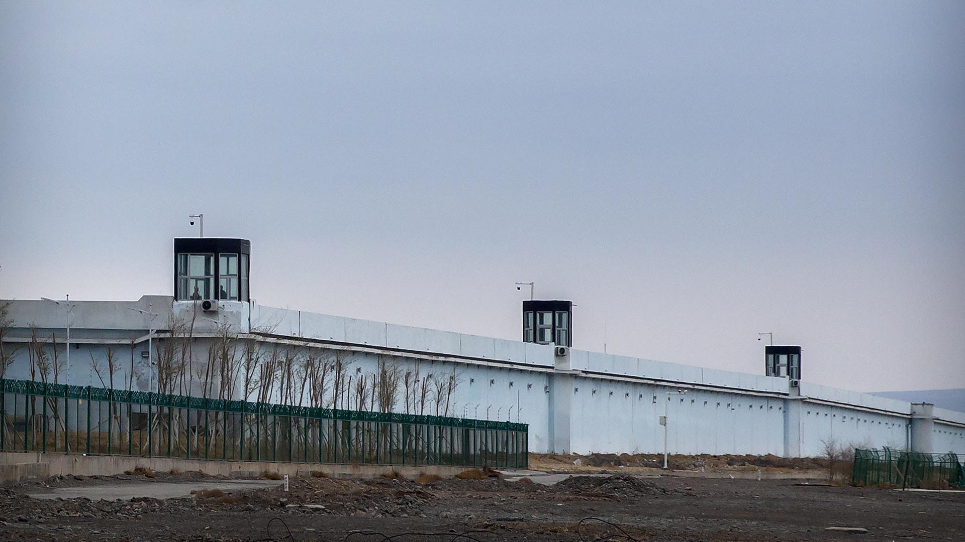 ARCHIVO - Personas de pie en una torre de vigilancia en el muro perimetral del Centro de Detención No. 3 de Urumqi en Dabancheng, en la Región Autónoma Uigur de Xinjiang, en el oeste de China, el 23 de abril de 2021.  (Foto AP/Mark Schiefelbein, archivo)