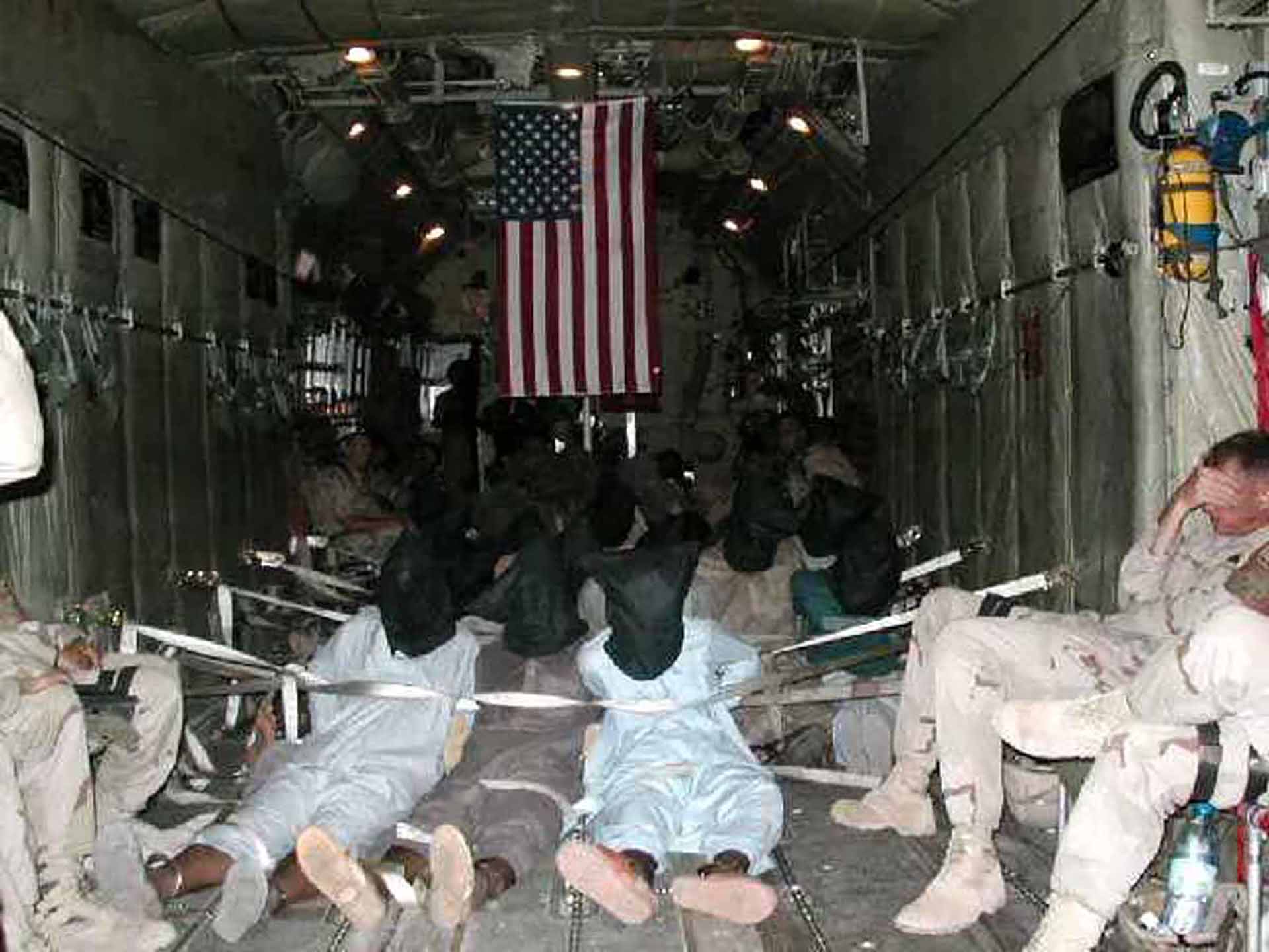 Esta foto publicada a AFP el 8 de noviembre de 2002 y enviada por correo electrónico de forma anónima a varias organizaciones de noticias, según los informes, muestra detenidos inmovilizados a bordo de un transporte militar estadounidense. (AFP)