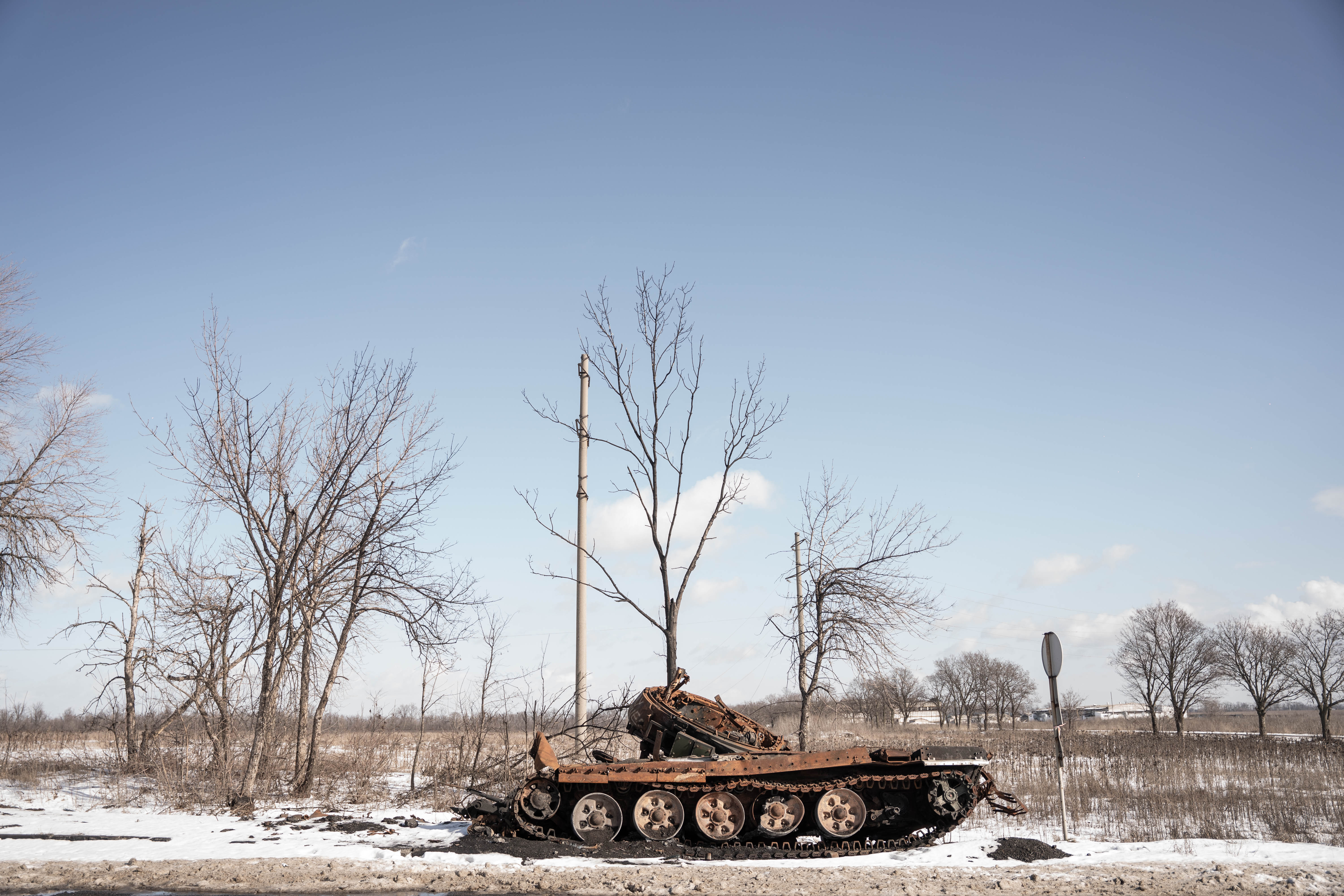 Equipamiento militar completamente calcinado y destrozado, una de las típicas postales de las rutas del Donbas