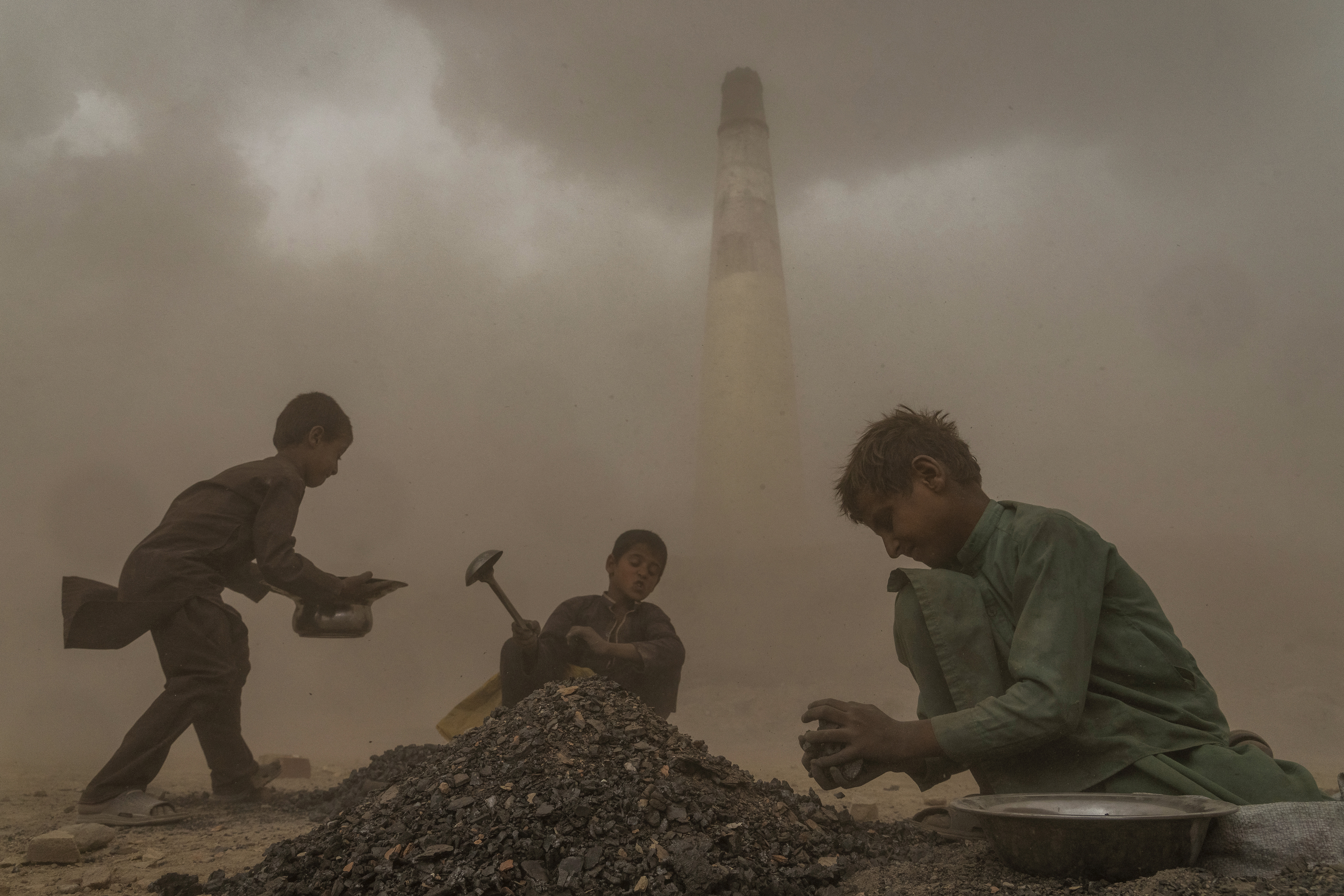 Niños afganos trabajan en una fábrica de ladrillos en las afueras de Kabul, Afganistán, el sábado 20 de agosto de 2022. 
