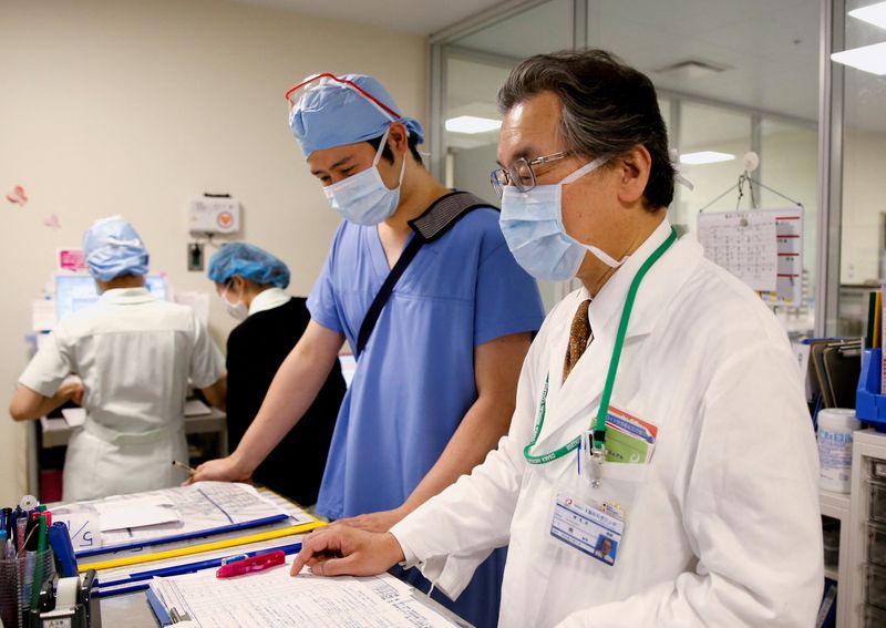 File photo of Dr. Toshiaki Minami, director of Osaka Medical and Pharmaceutical University Hospital, working with colleagues in the hospital's operating wing amid the COVID-19 pandemic, in Takatsuki, Osaka prefecture, Japan.  May 17, 2021. REUTERS/Akira Tomoshige/File