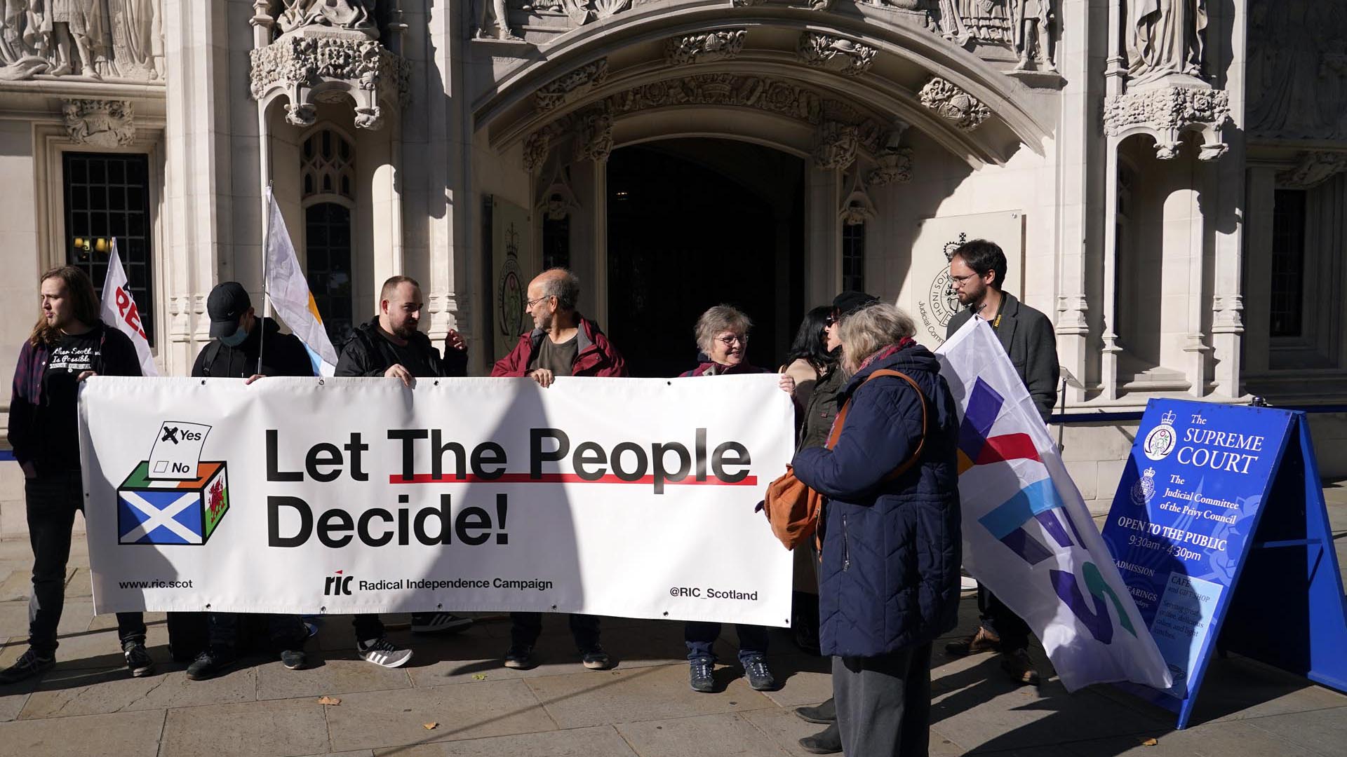 Los partidarios de la Independencia de Escocia sostienen una pancarta que dice: "Dejen a las personas decidir!" frente a la Corte Suprema en Londres, el martes 11 de octubre de 2022.  (Foto AP/Alberto Pezzali, Archivo)
