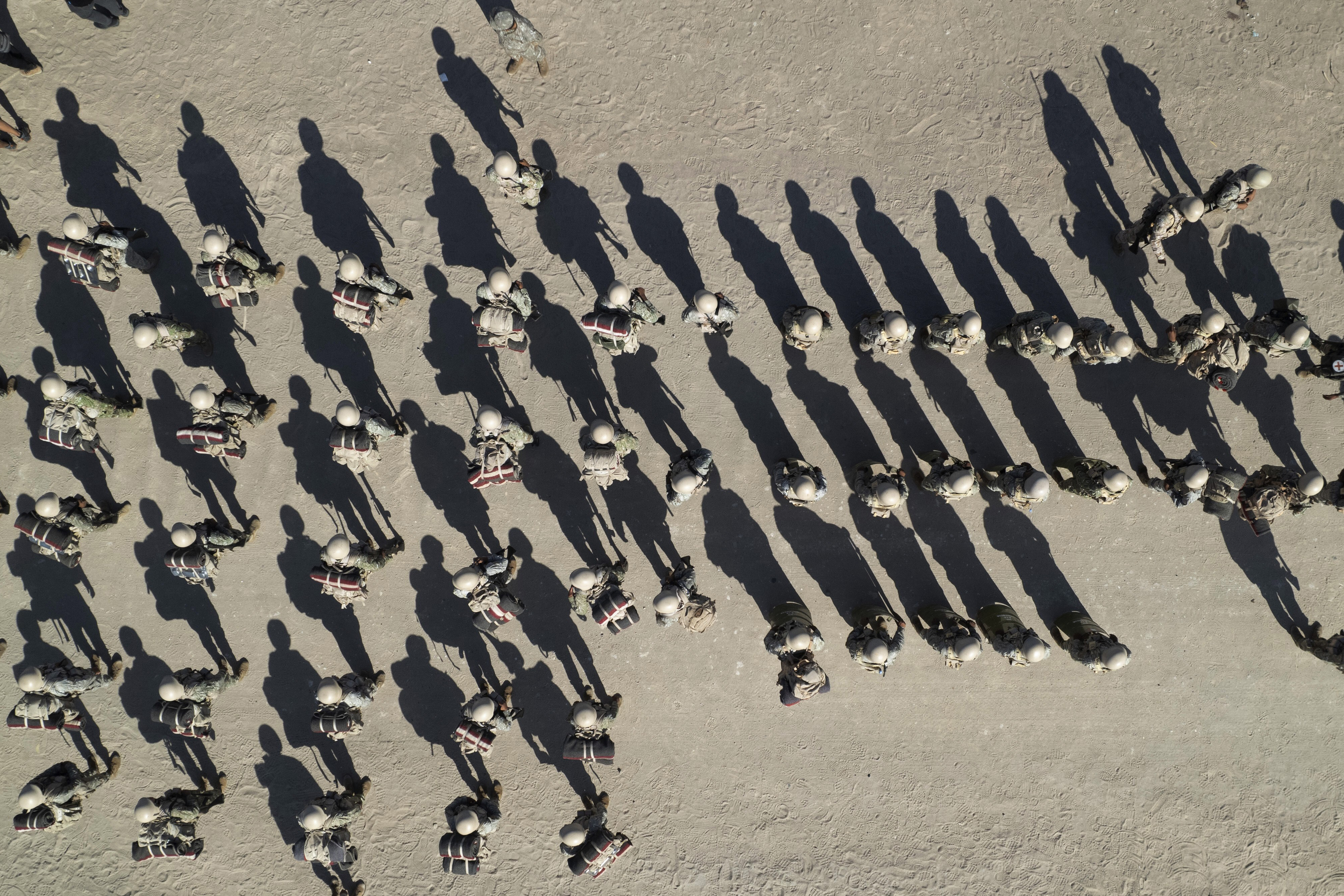 Peruvian military personnel are seen from above at the country's border with Chile, in Tacna, Peru, Friday, April 28, 2023. The migration crisis on the Chile-Peru border intensified on Thursday with hundreds of migrants left stranded. at the border limit, without being able to cross into Peru.  (AP Photo/Martín Mejía)
