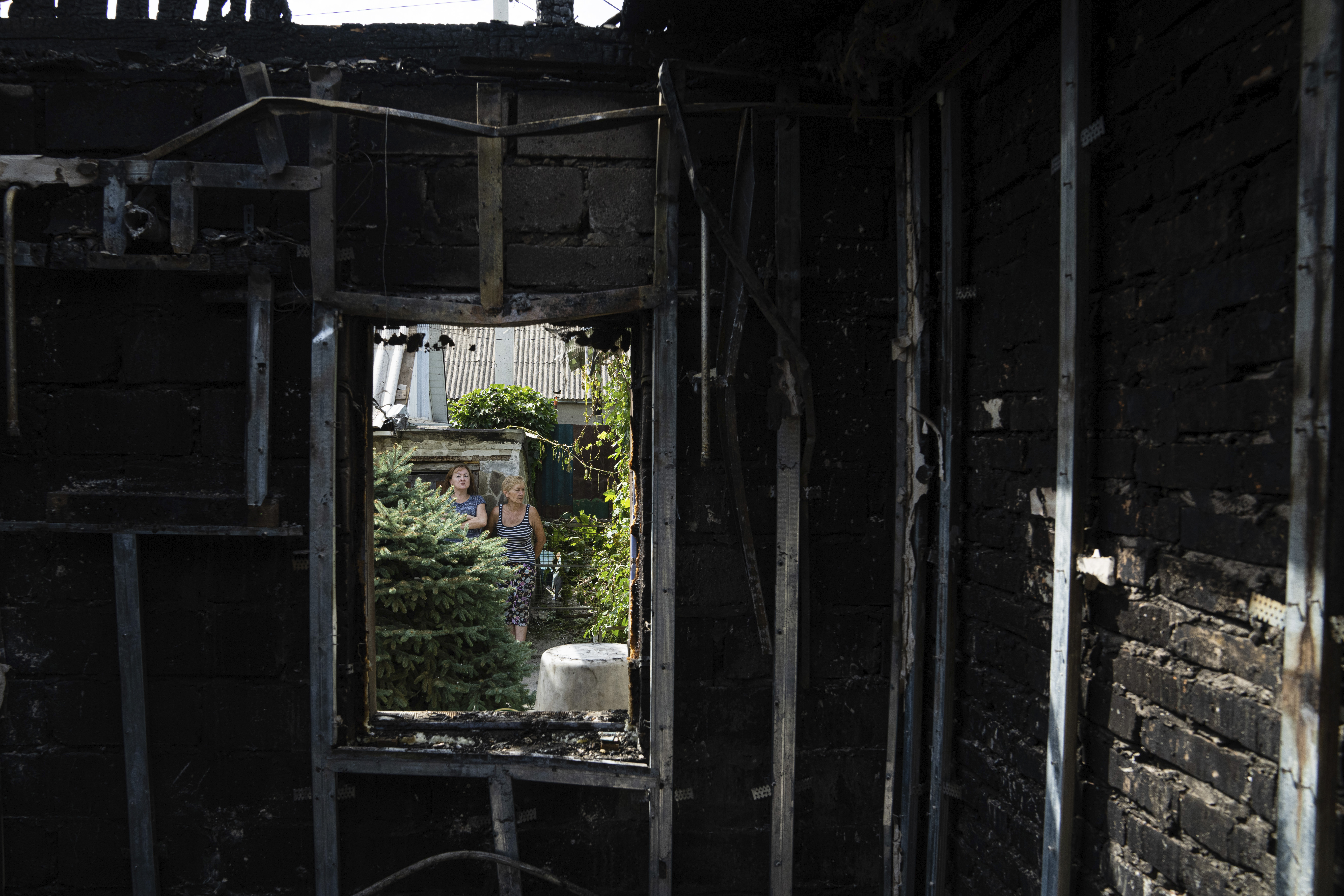 People look at a destroyed house after Russian shelling hit a residential area in Nikopol, Ukraine on August 22, 2022.  (AP Photo/Evgeny Maloletka, File)