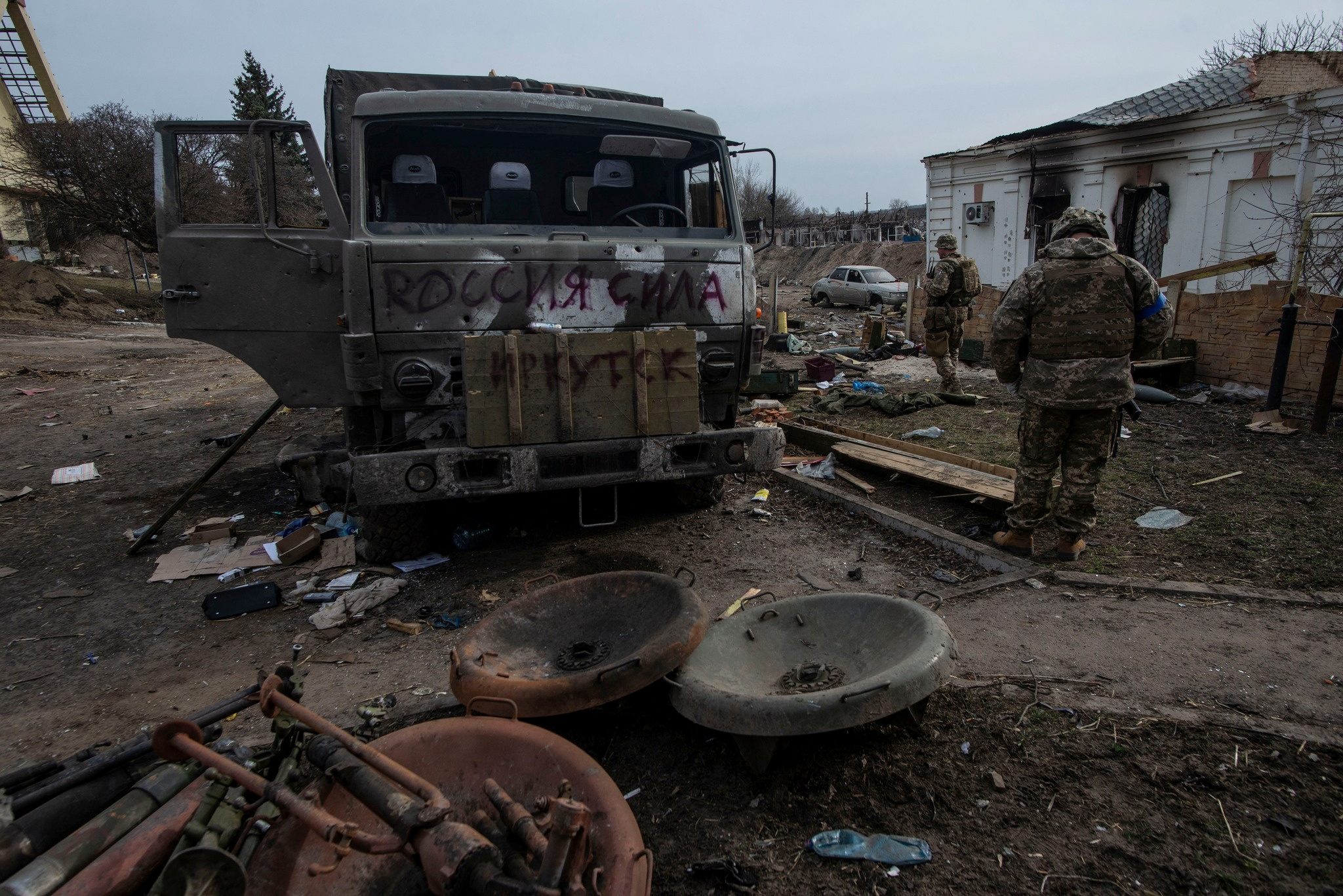 Ukrainian service members stand next to a destroyed Russian military vehicle, as Russia's attack on Ukraine continues, in the town of Trostianets, in Sumy region, Ukraine, in this handout picture released March 27, 2022. Press service of the Ukrainian Ground Forces/Handout via REUTERS THIS IMAGE HAS BEEN SUPPLIED BY A THIRD PARTY.