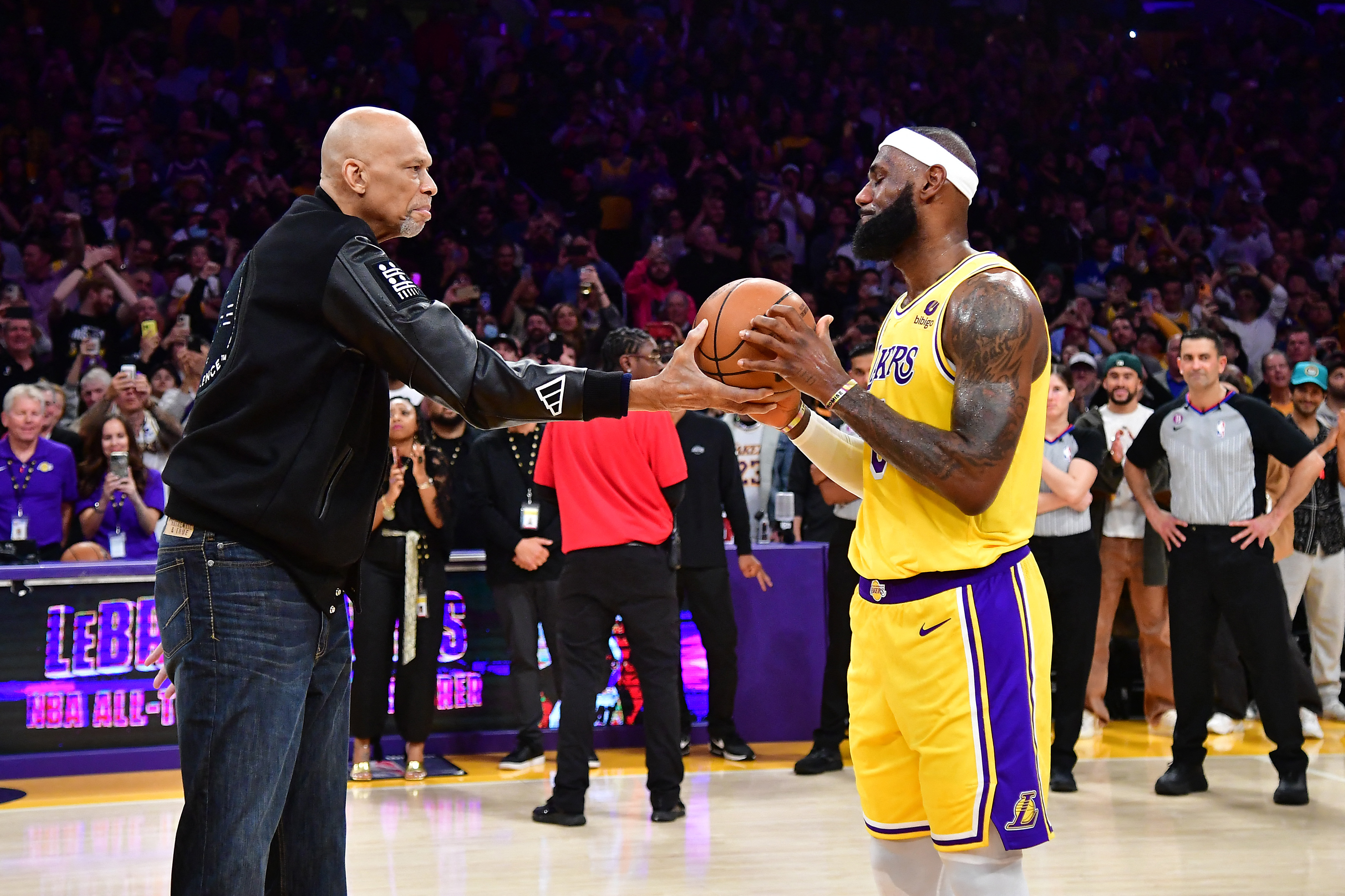 El jugador de Los Angeles Lakers, Kareem Abdul-Jabbar, entrega el balón al delantero LeBron James (6) después de que James se convierte en el líder anotador de todos los tiempos de la NBA contra el Oklahoma City Thunder durante la segunda mitad en el Crypto.com Arena. (Gary A. Vasquez-USA TODAY Sports)