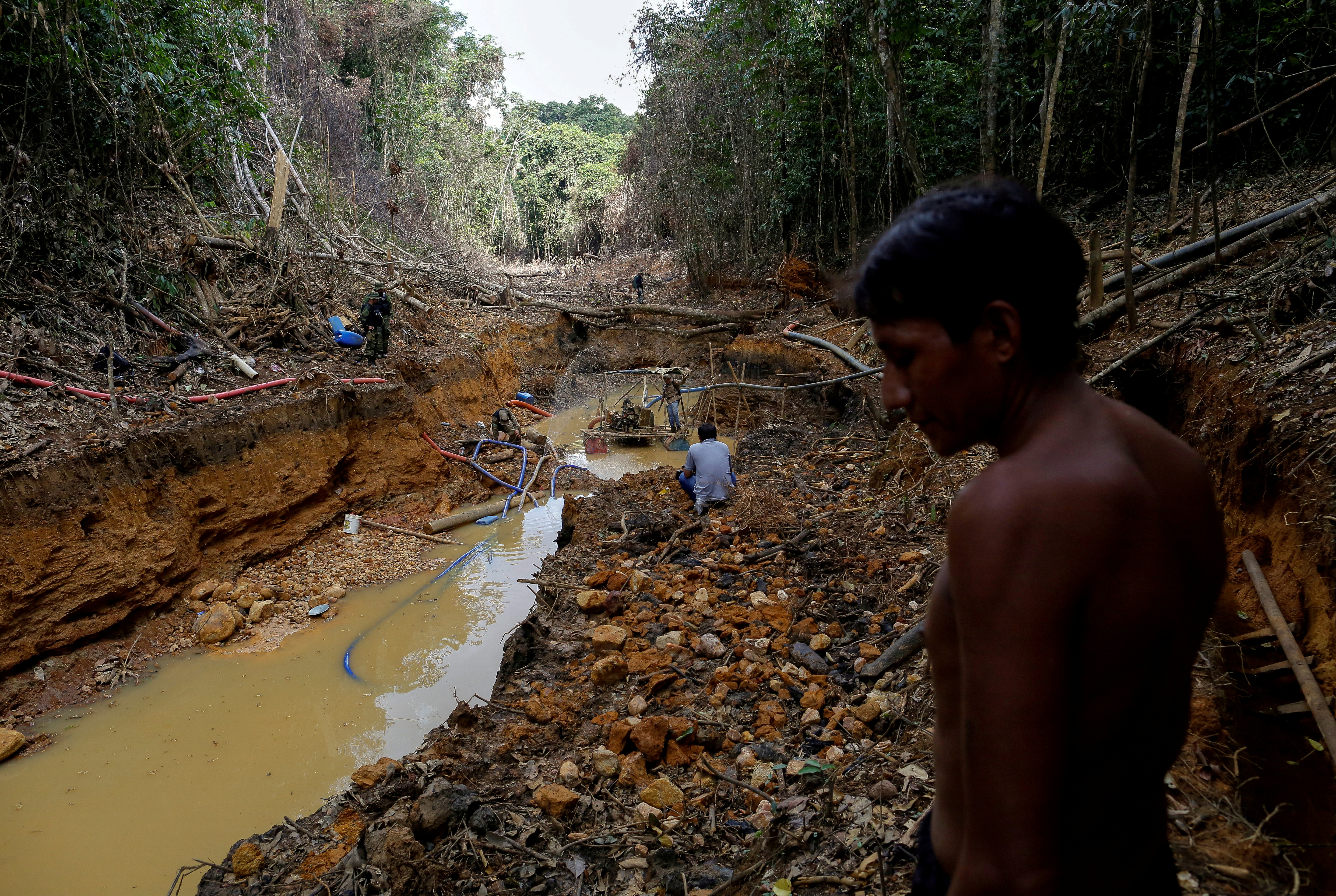 FOTO DE ARCHIVO: Un indio yanomami sigue a agentes de la agencia ambiental de Brasil en una mina de oro durante una operación contra la minería ilegal de oro en tierras indígenas, en el corazón de la selva amazónica, en el estado de Roraima, Brasil (REUTERS)