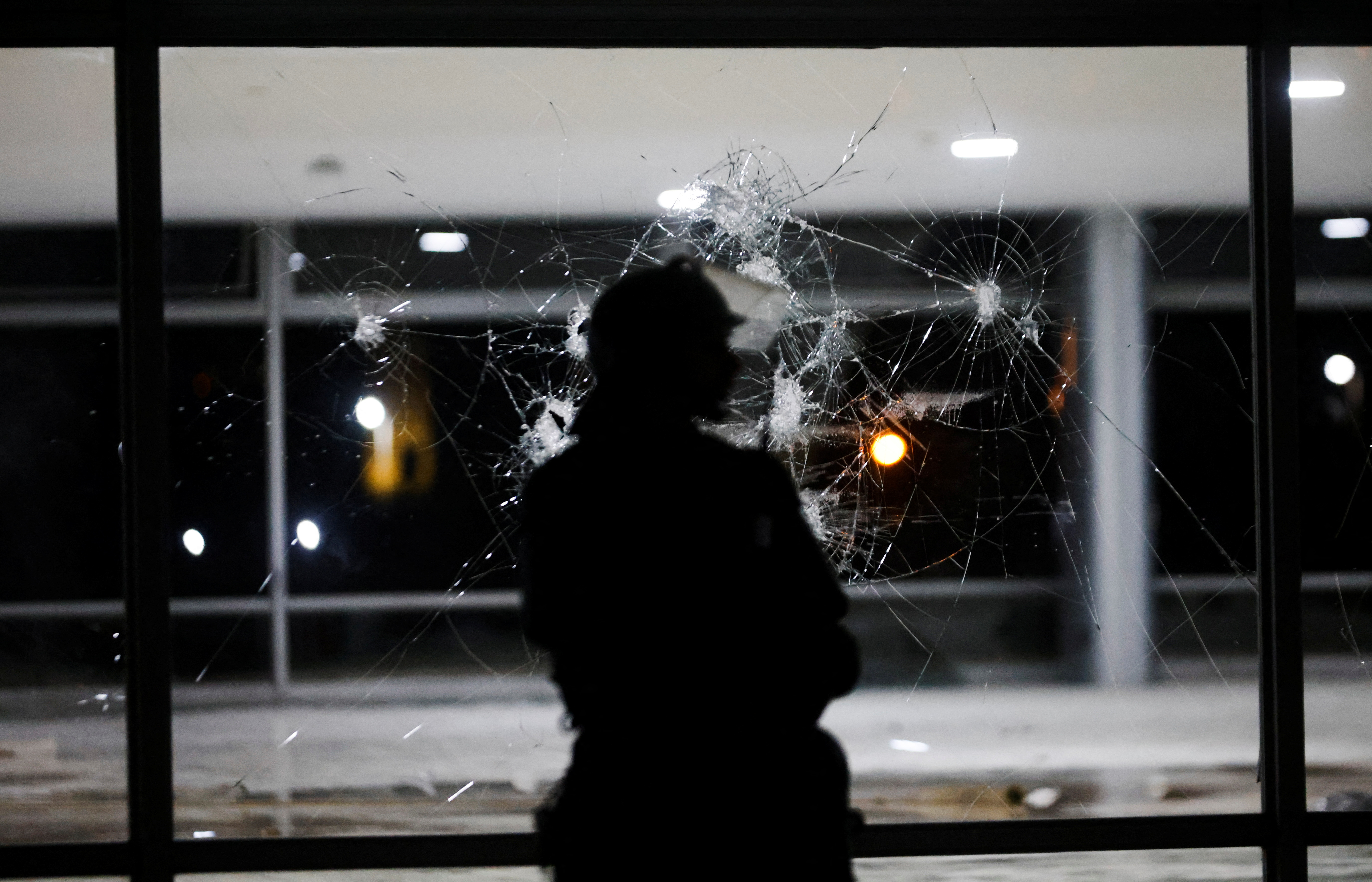 A soldier stands in front of a broken glass panel at Planalto Palace following a protest by supporters of Brazil's former President Jair Bolsonaro against President Luiz Inacio Lula da Silva, in Brasilia, Brazil, January 8, 2023. REUTERS/Adriano Machado