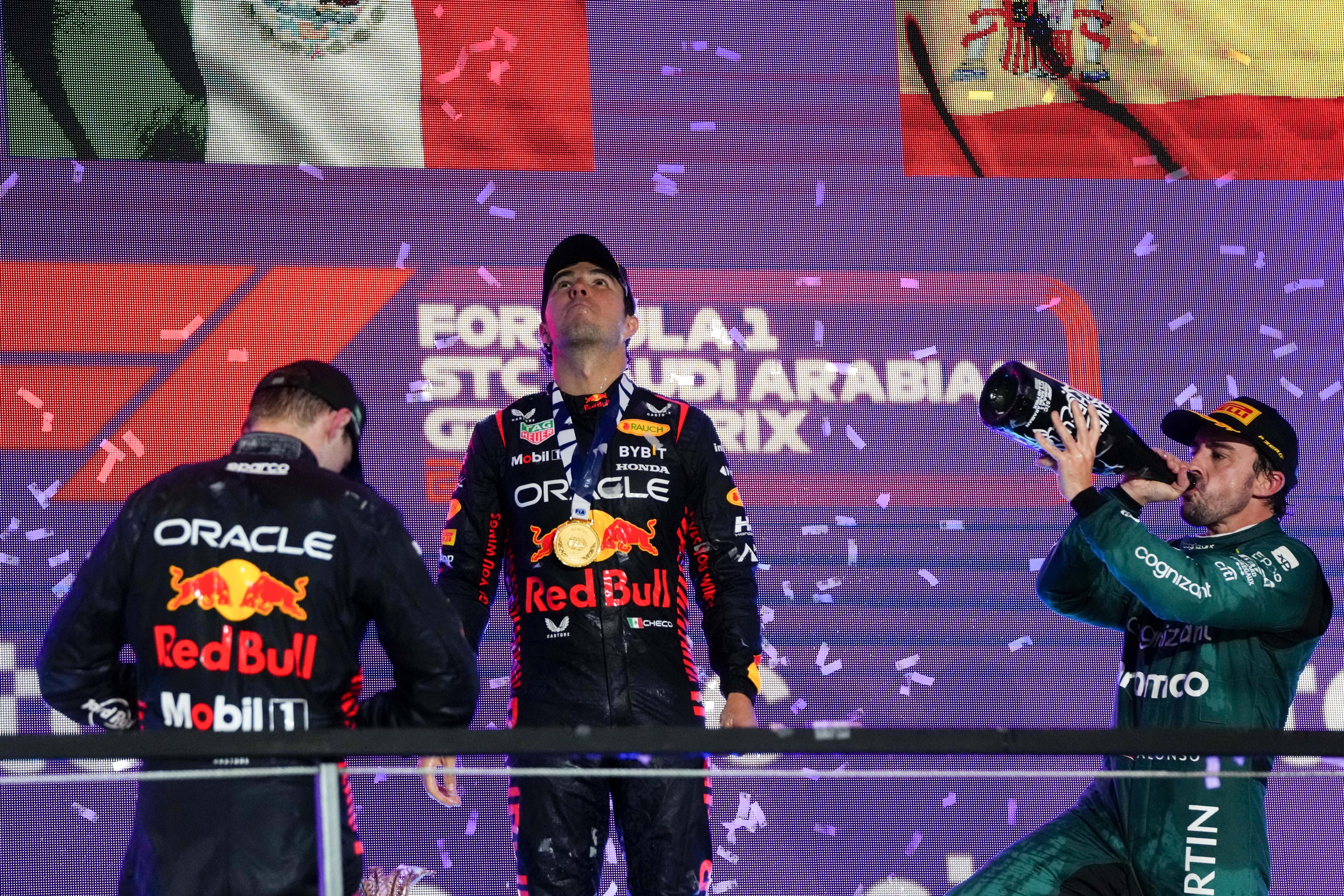 Sergio Pérez (centro) de Red Bull celebra tras ganar el Gran Premio de Arabia Saudí, escoltado por Max Verstappen (izquierda) de Red Bull y Fernando Alonso (derecha) de Aston Martin, el domingo 19 de marzo de 2023. (AP Foto/Hassan Ammar)