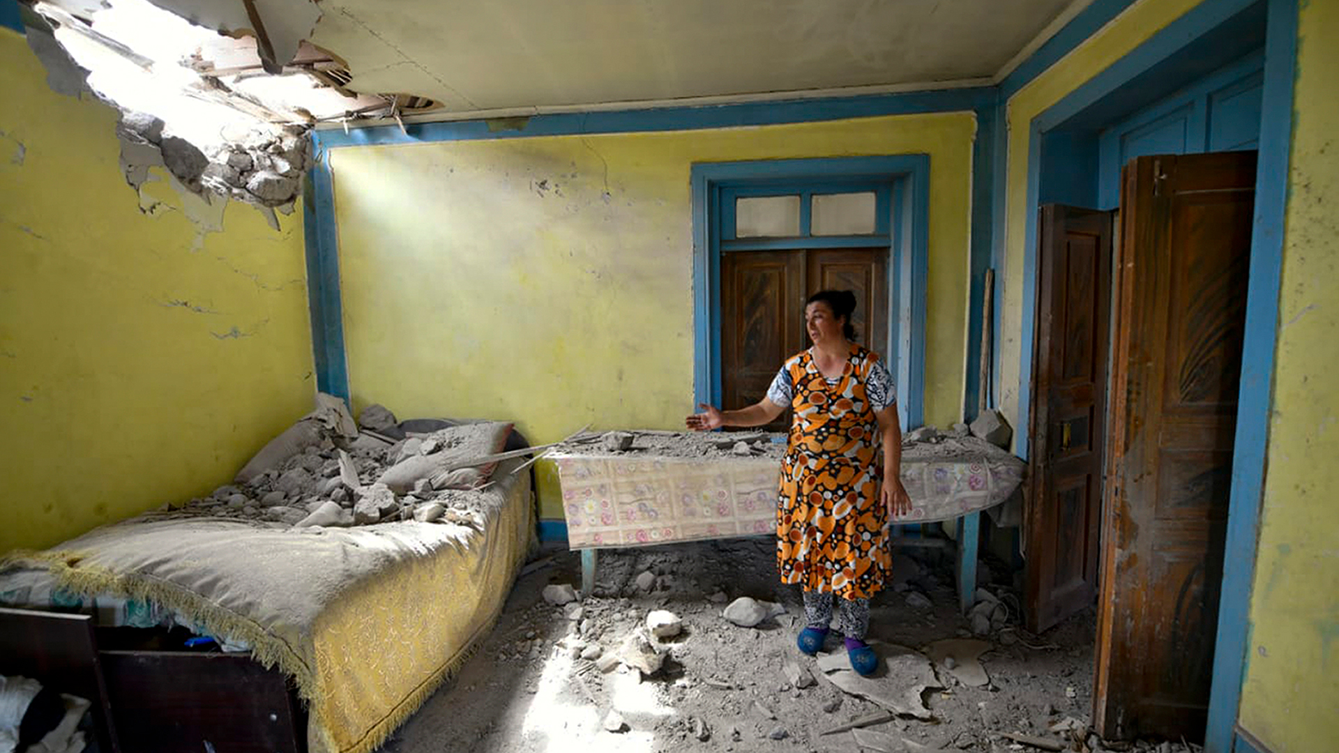 Una residente de la región de Tovuz, el Azerbaiyán, muestra los daños producidos en su casa por parte de la artillería armenia.
(AP Photo/Ramil Zeynalov)