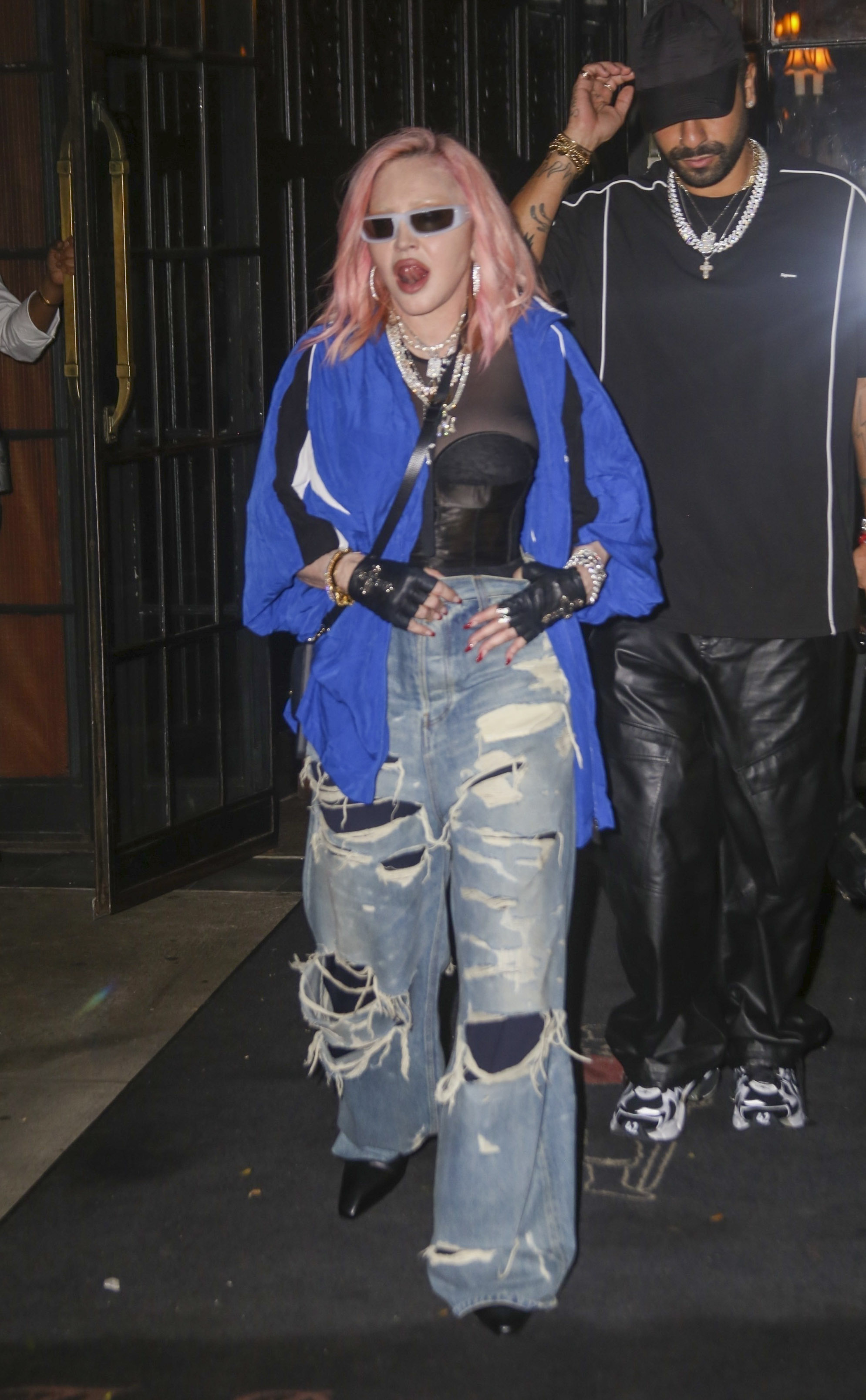 An elegant Madonna is escorted by her security out of the Bowery Hotel in New York City after attending a party.  The legendary artist wore a black bustier with ripped jeans, a blue jacket and her hair dyed light pink.