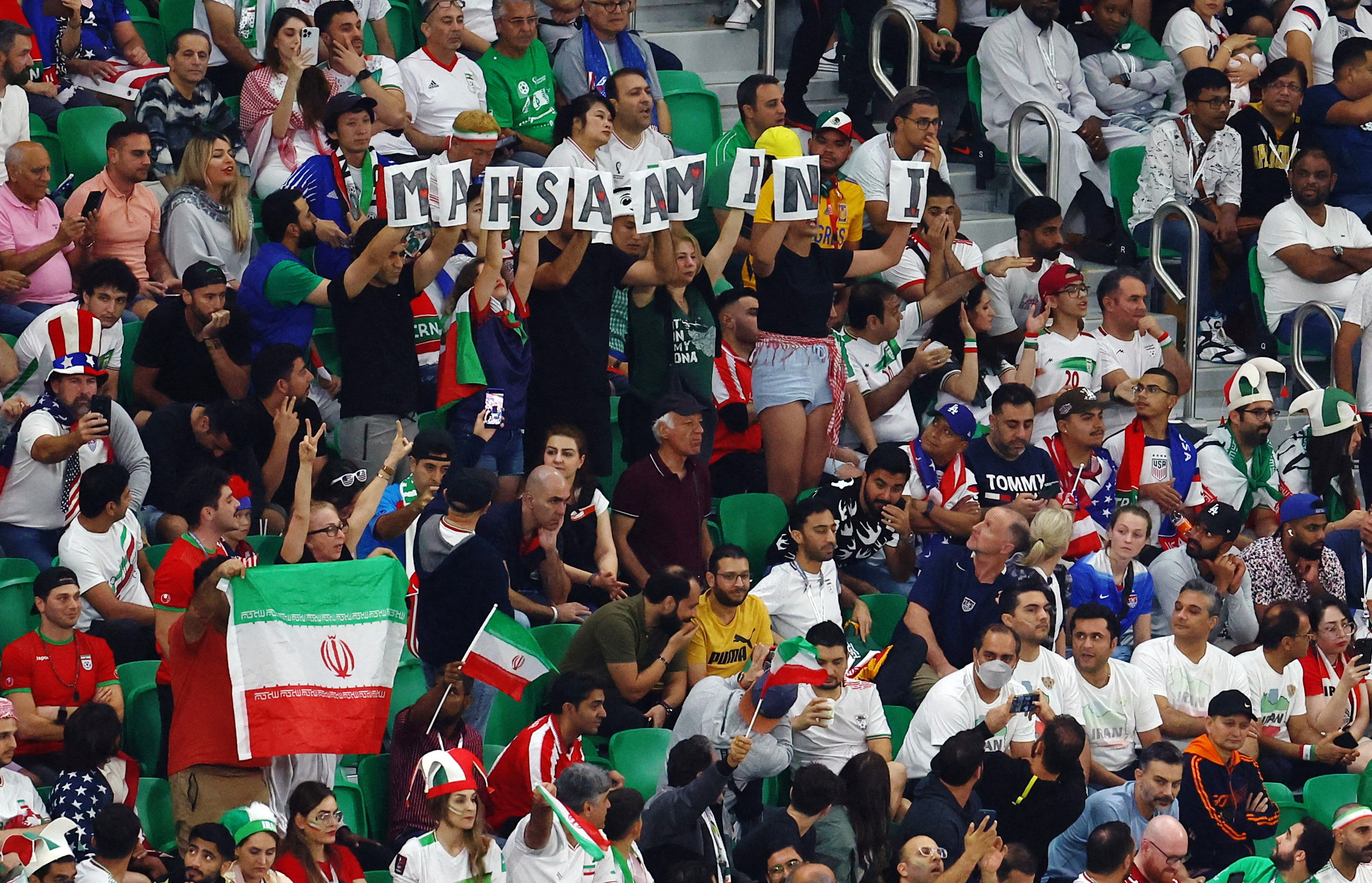 Un grupo de hinchas de Irán despliegan pancartas que arman el nombre de Mahsa Amini, la chica asesinada por el régimen de los ayatollahs que desató una ola de protestas. (REUTERS/Molly Darlington)    