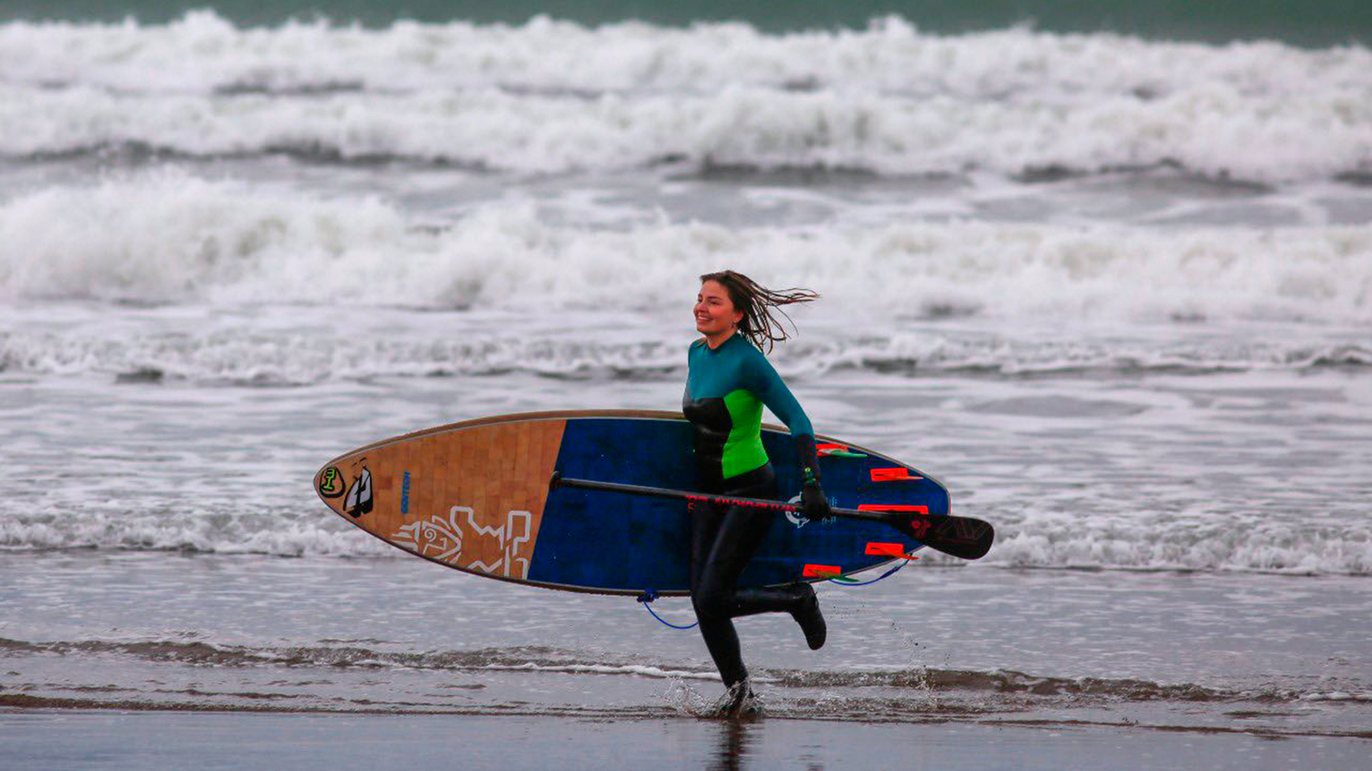 Una chica sale del agua con su equipo de padel surf. El mar se abrió para los que desafiaron las bajas temperaturas (@munimardelplata)