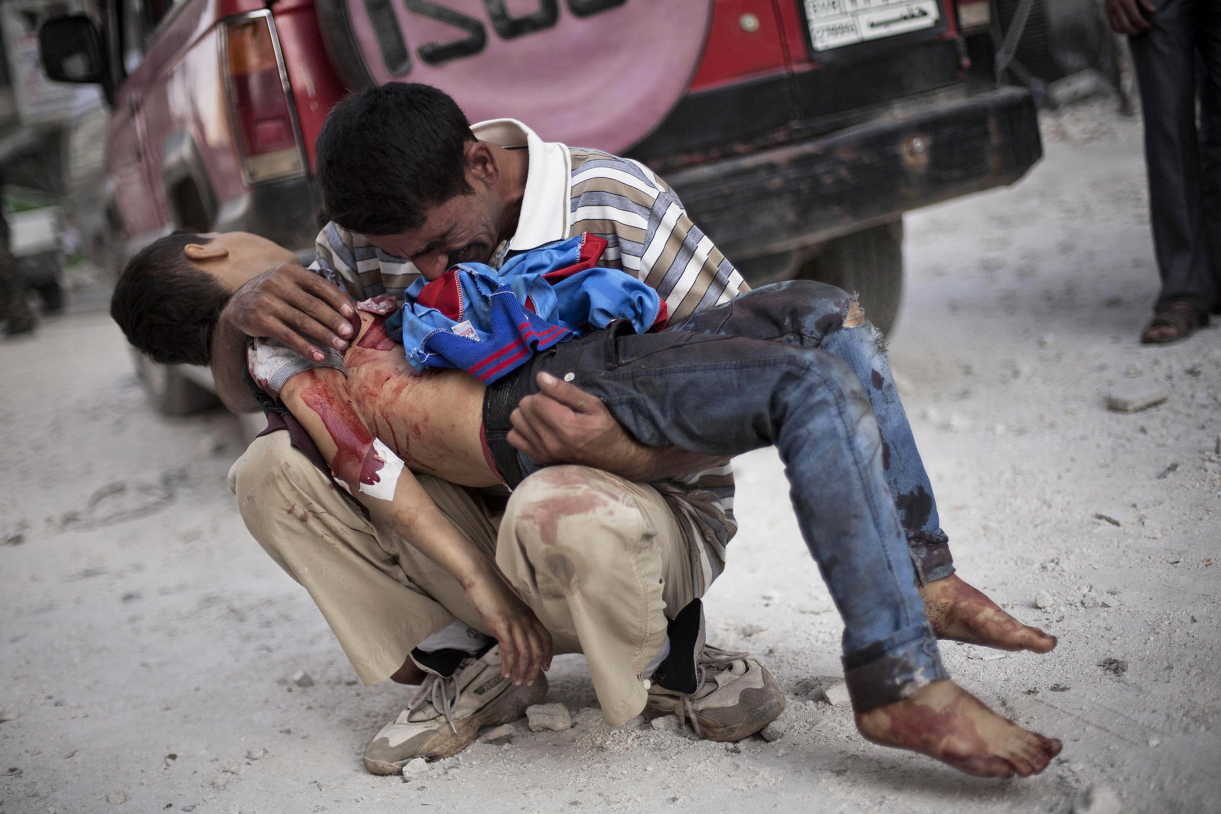 Un hombre llora sobre el cuerpo de su hijo cerca del hospital Dar Al Shifa en Alepo, Siria, 3 de octubre de 2012 (AP Photo/Manu Brabo)